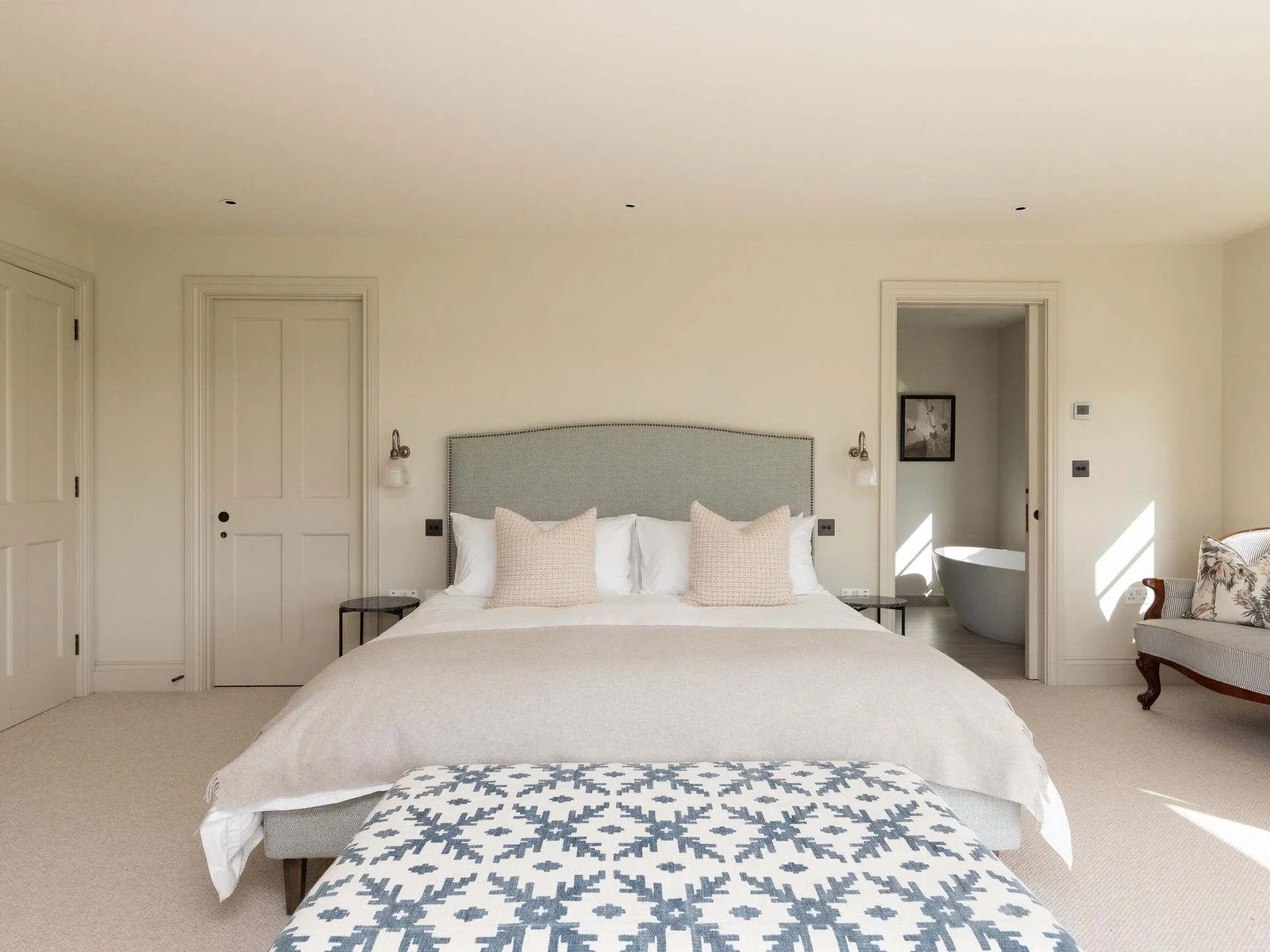 Spacious king bedroom with ensuite access, luxurious linens, and a calm, relaxing atmosphere.