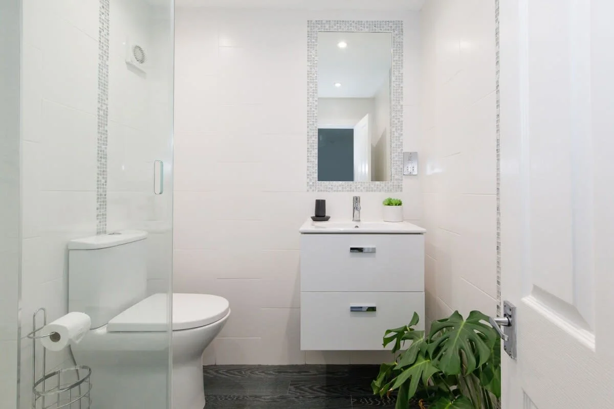 The family bath has a spacious walk in shower with WC and sink.