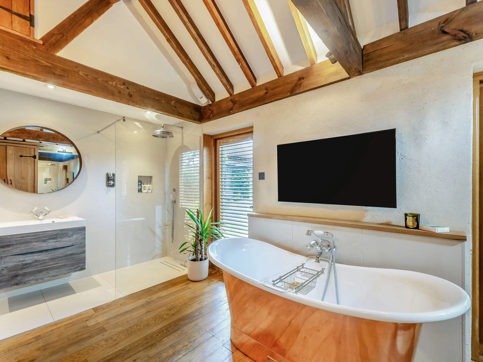 A luxurious en-suite to bedroom 2 with copper roll-top bath, walk-in shower and TV.