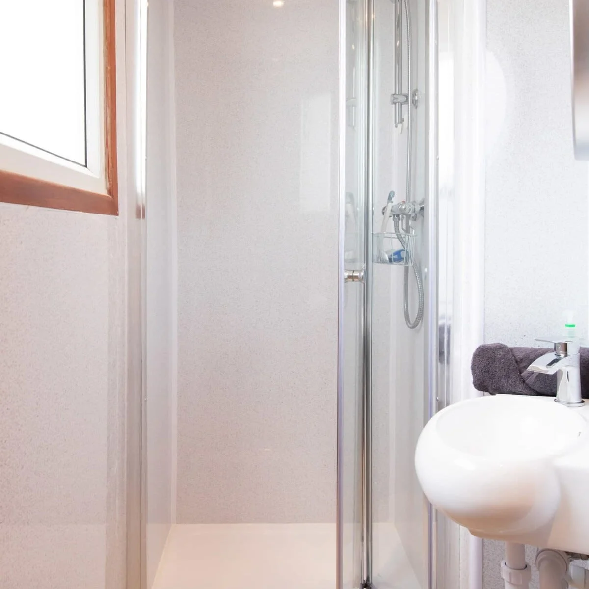 The second bathroom with a walk in shower, sink, toilet and heated towel rail