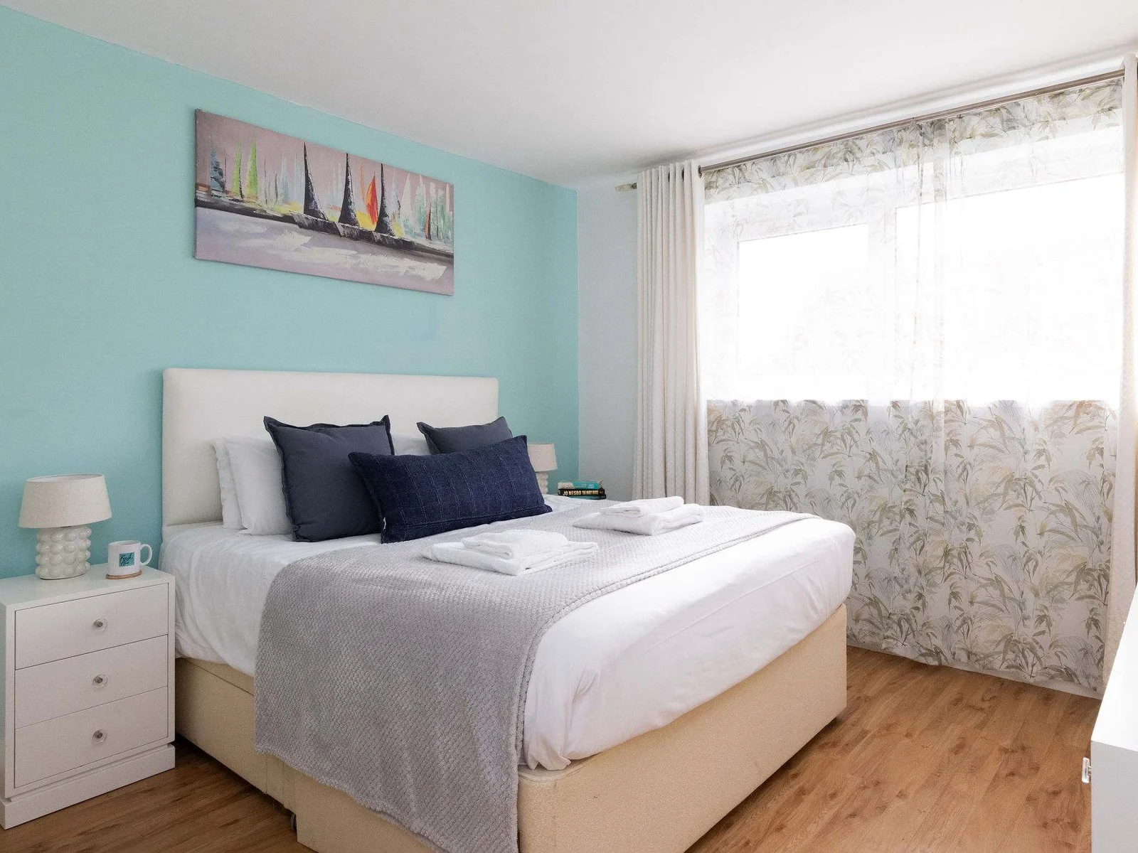 Bright double bedroom with fresh linens, soft lighting, and calming coastal tones for a restful seaside stay.