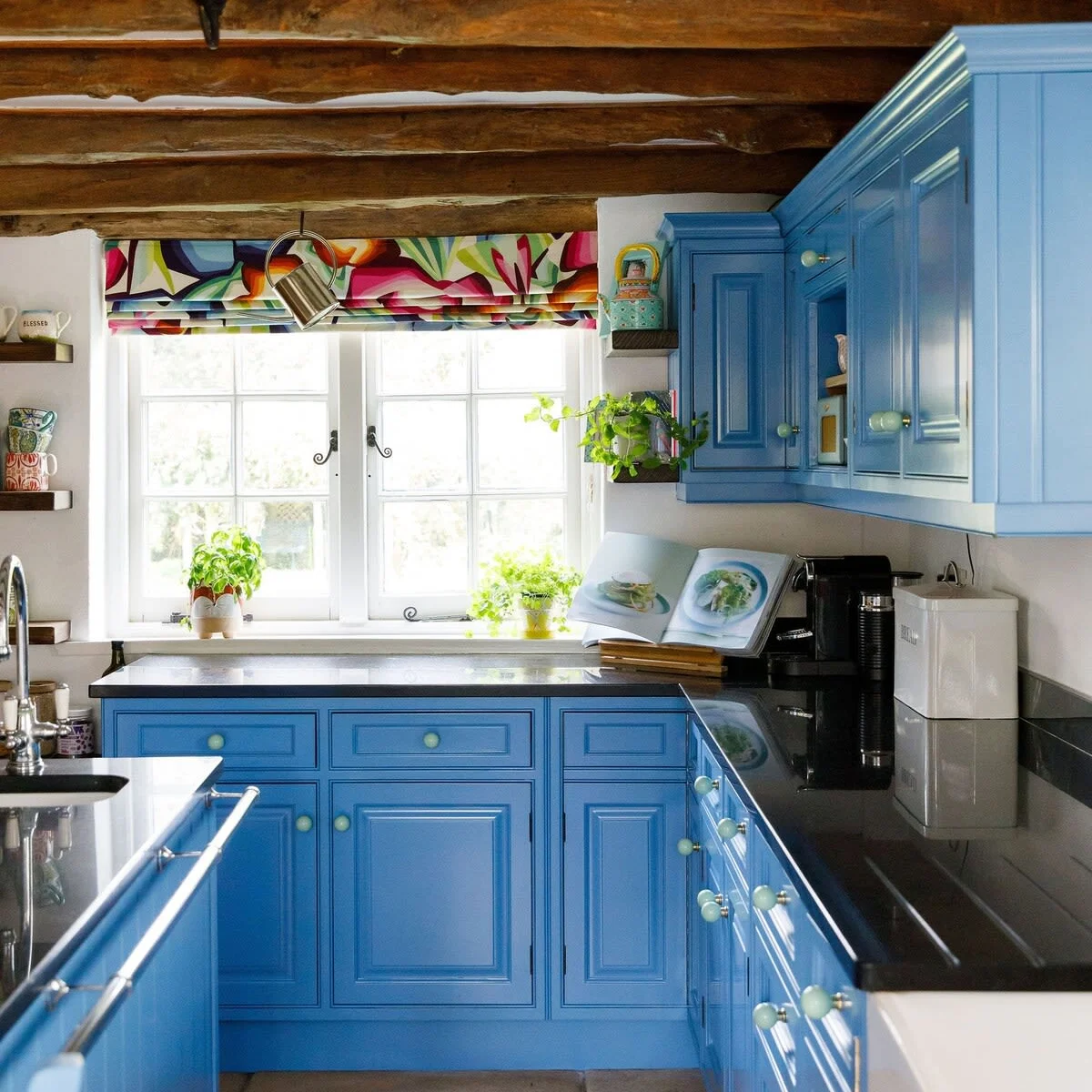 The blue farmhouse style kitchen is well stocked with herbs, spices and oils.
