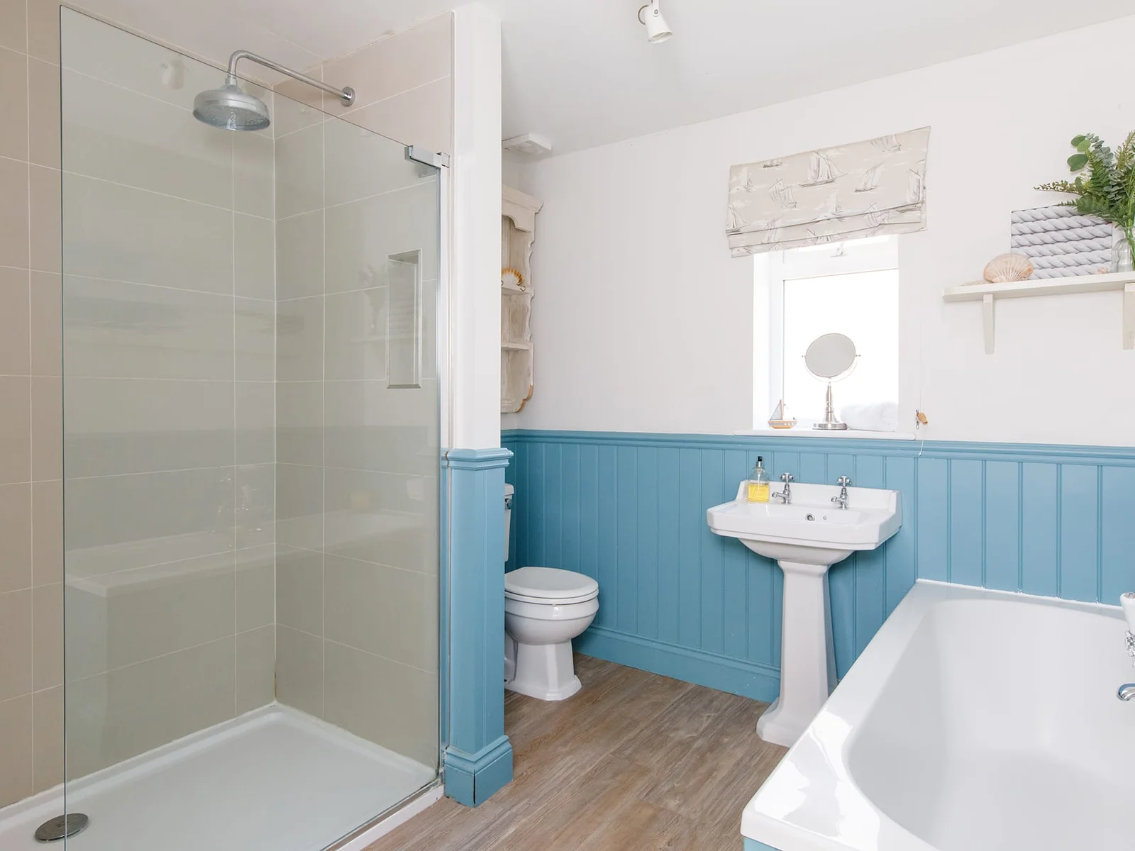 The bathroom is spacious with a large separate shower and bath with shower head.