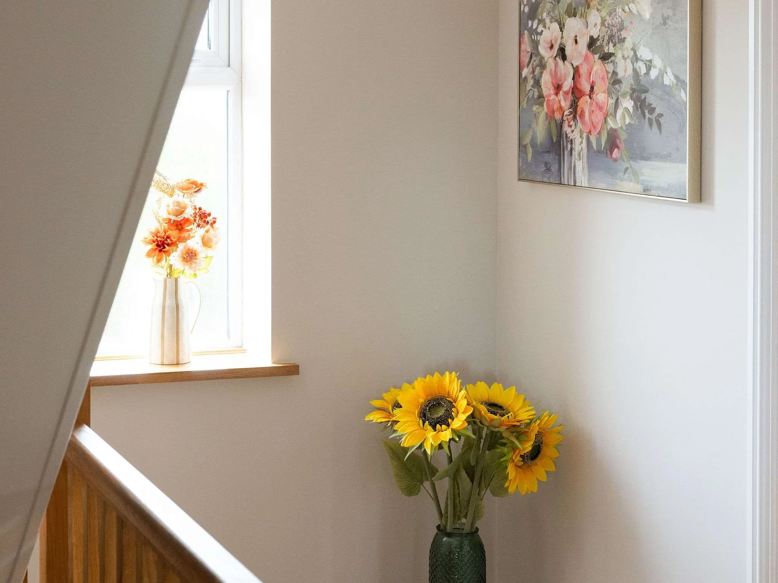 A light-filled landing with warm wood detailing, soft artwork and cheerful touches.