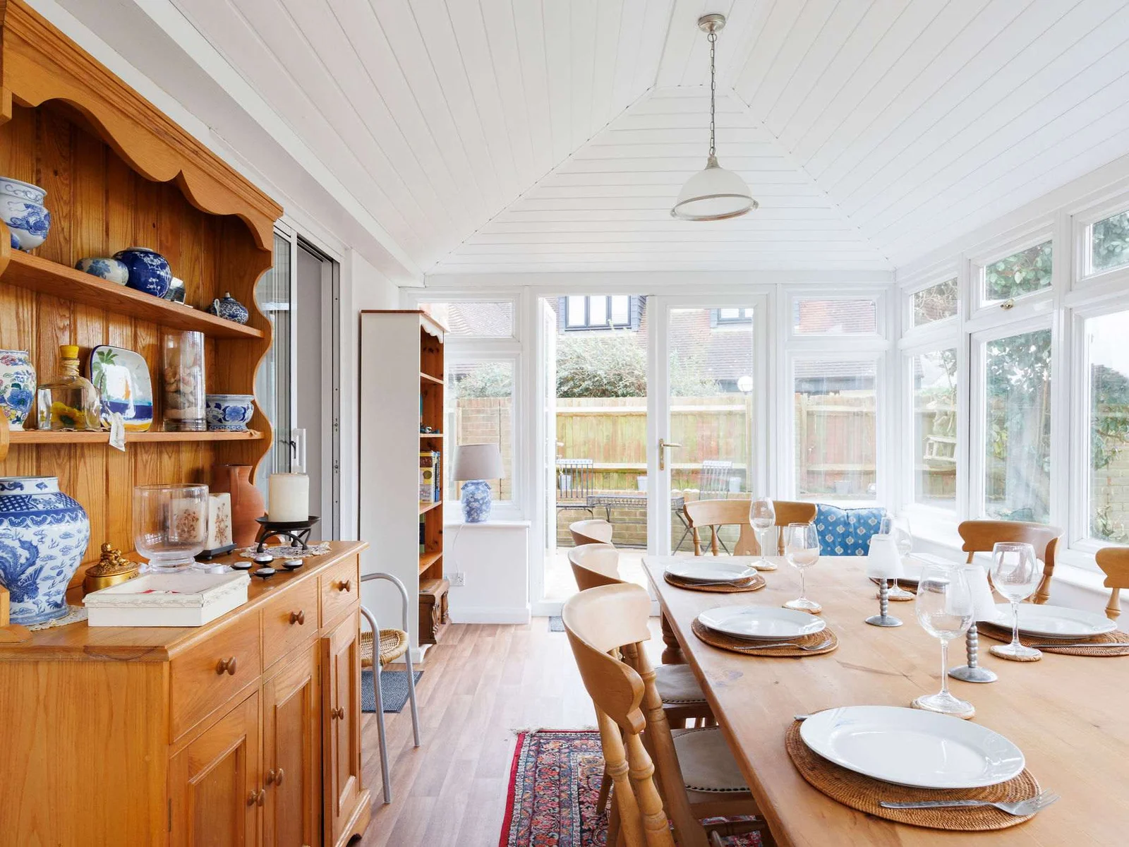 The light and bright conservatory has a large dining table for long, leisurely meals with loved ones.