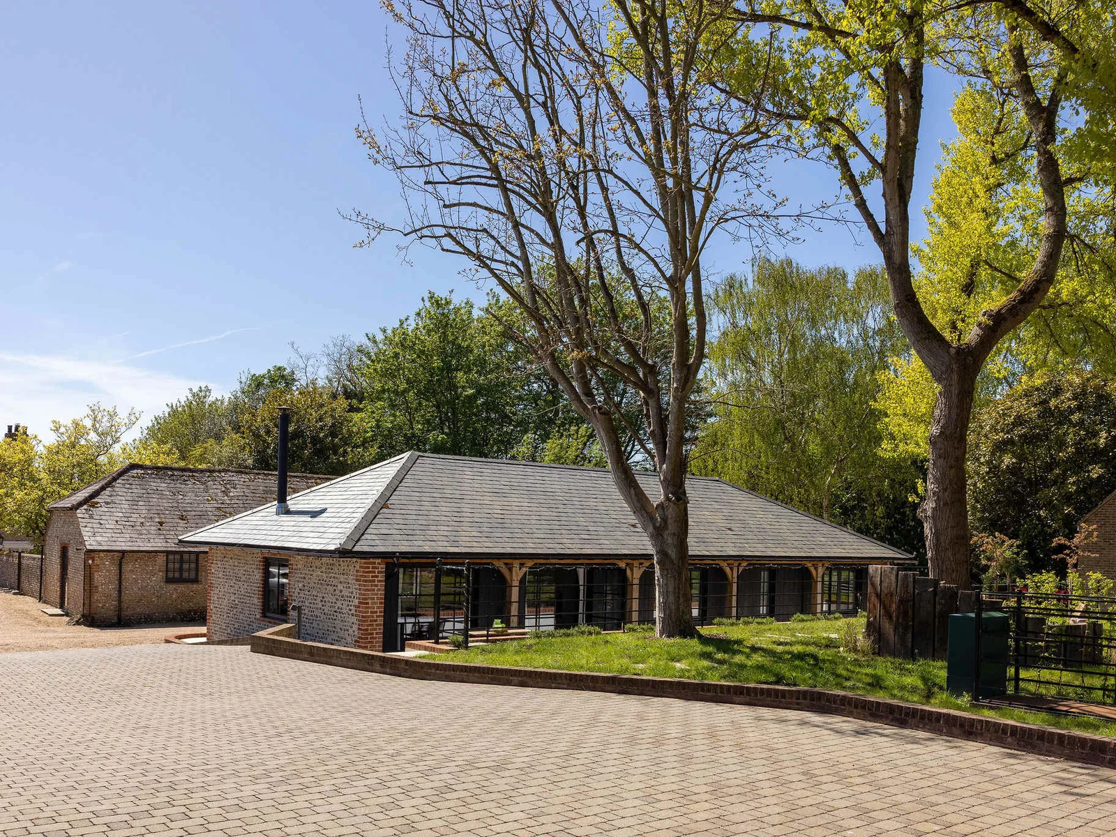 Arrive easily to a private gravel courtyard, framed by timber details and leafy rural surroundings.