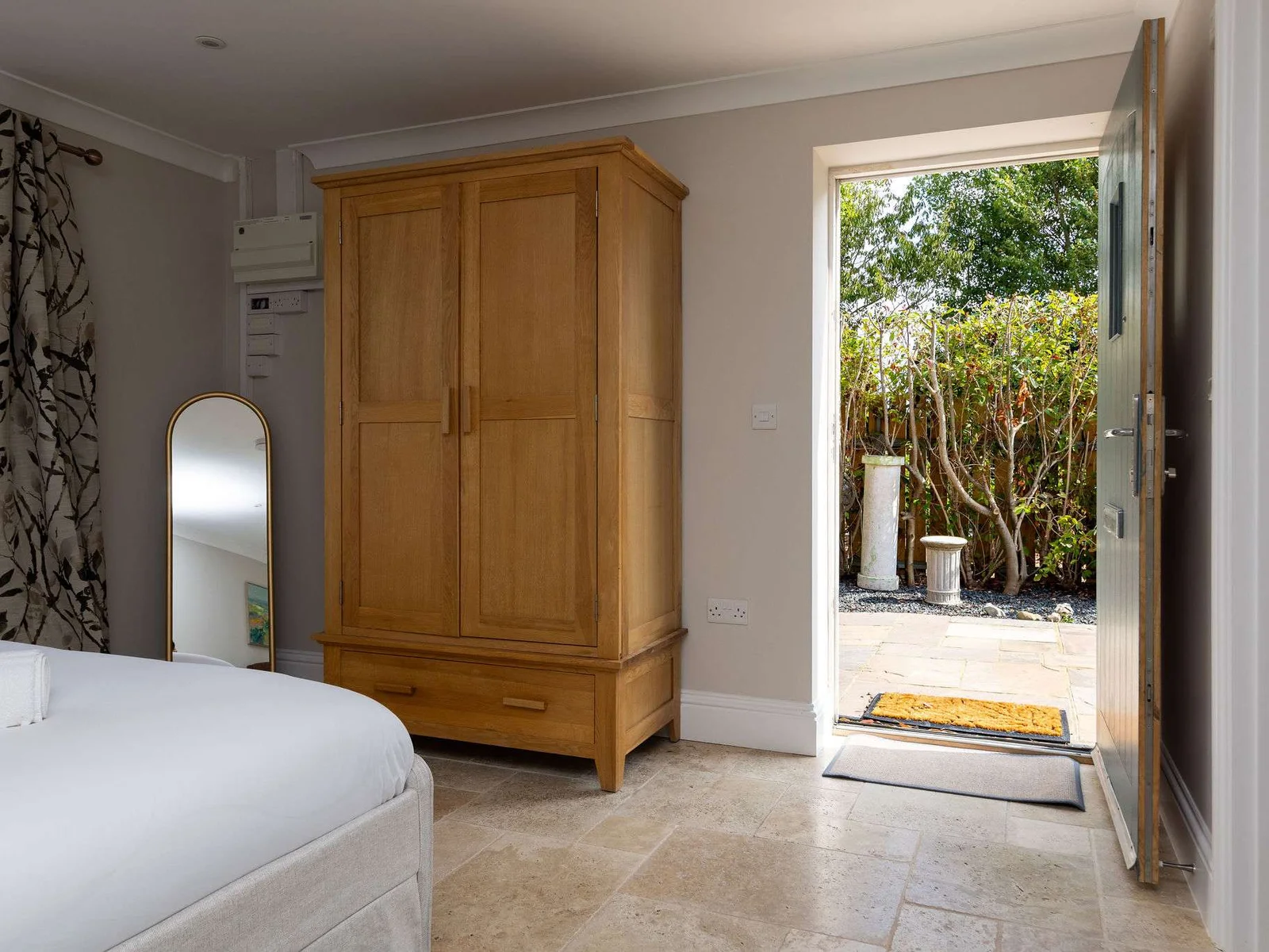 The ground-floor double bedroom opens directly outside to a small seating area — perfect for slow mornings with a coffee in the fresh country air.
