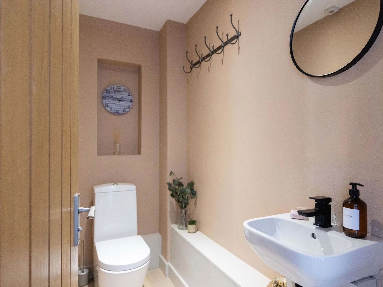 A beautifully finished cloakroom with a fresh, modern feel and a stylish statement basin, adding a touch of luxury to the space.