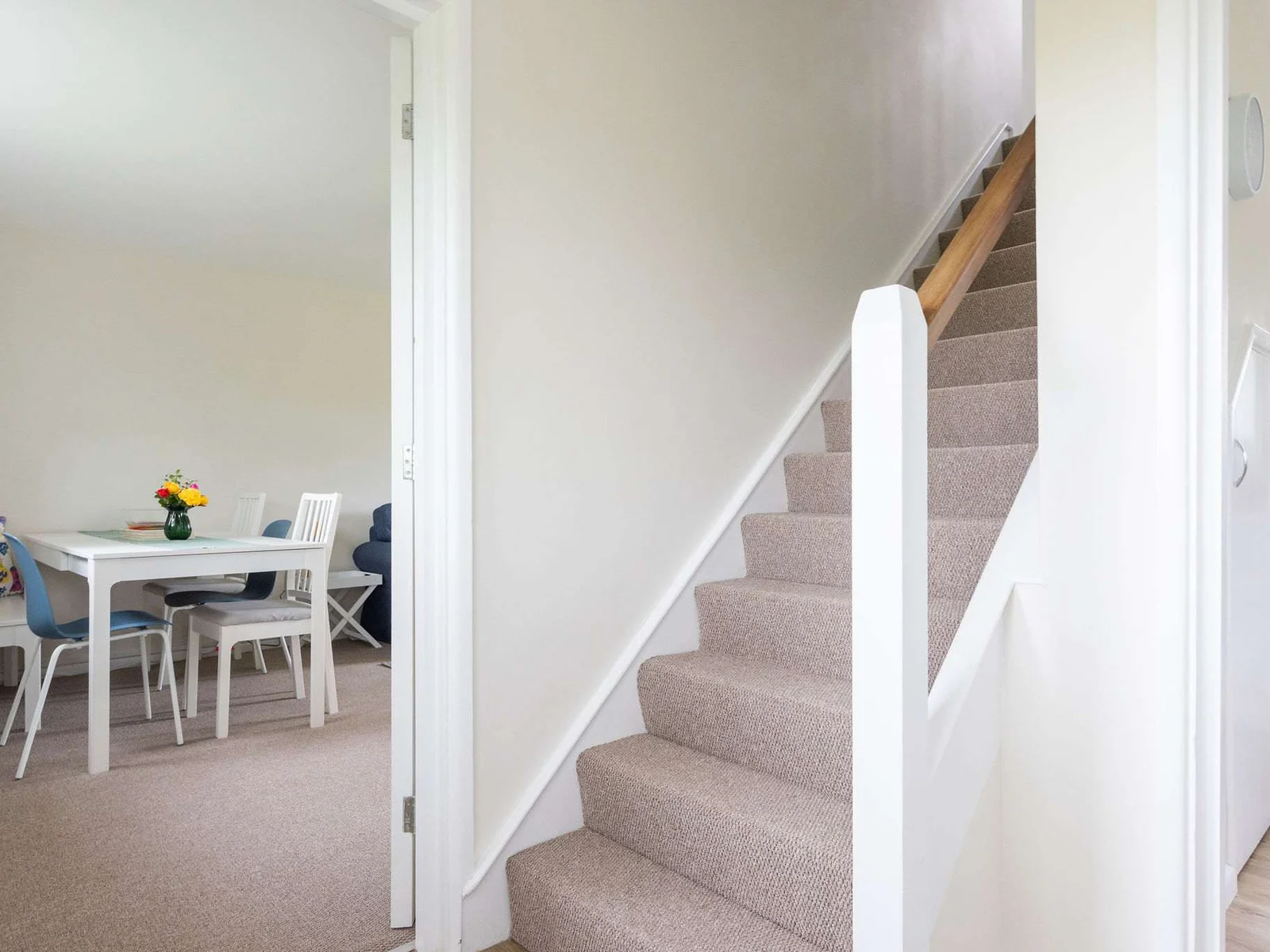Dining area and kitchen area separated by stairs.