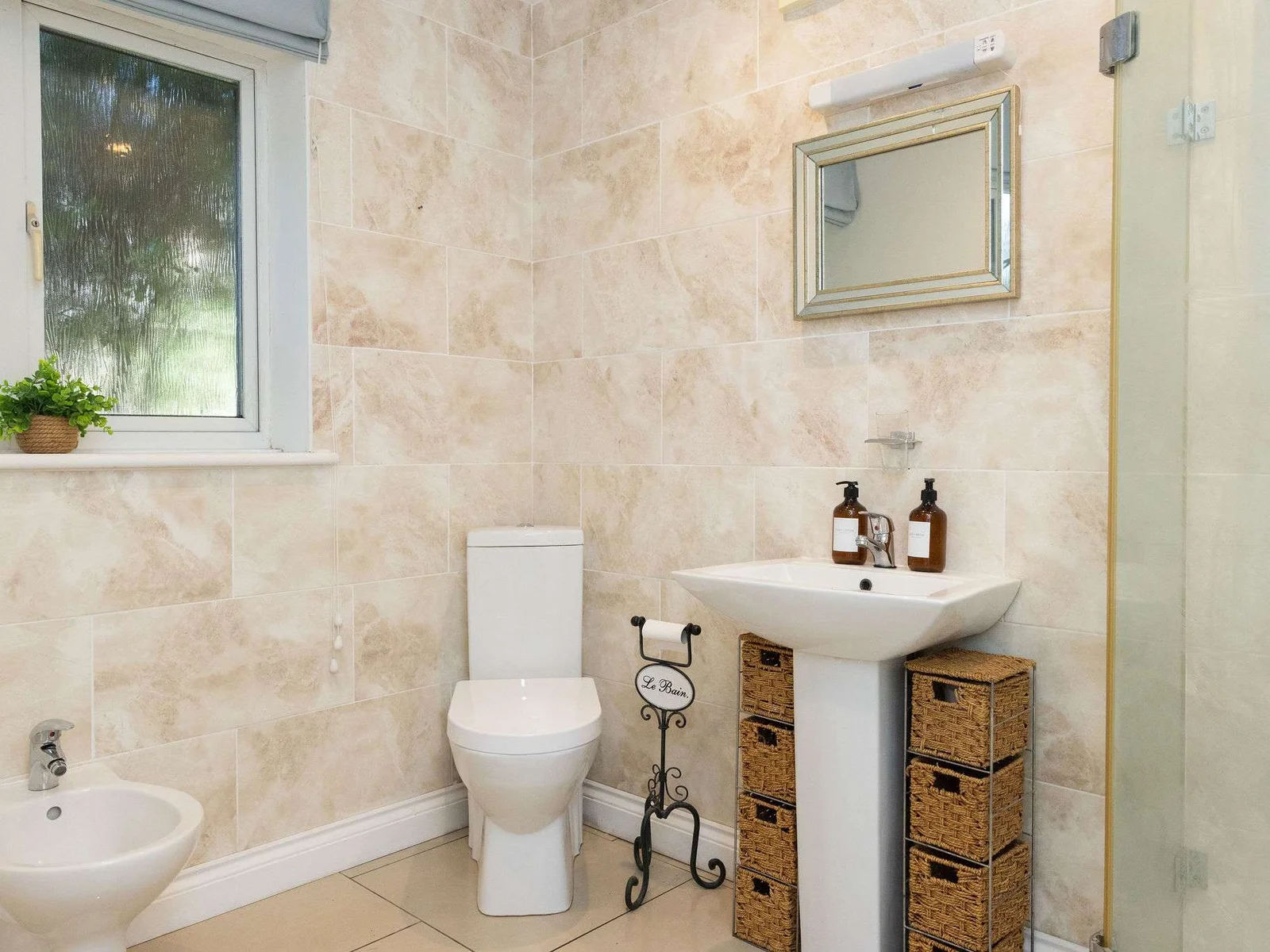 Appreciate the elegant stone tiling in the second modern bathroom of your family getaway.