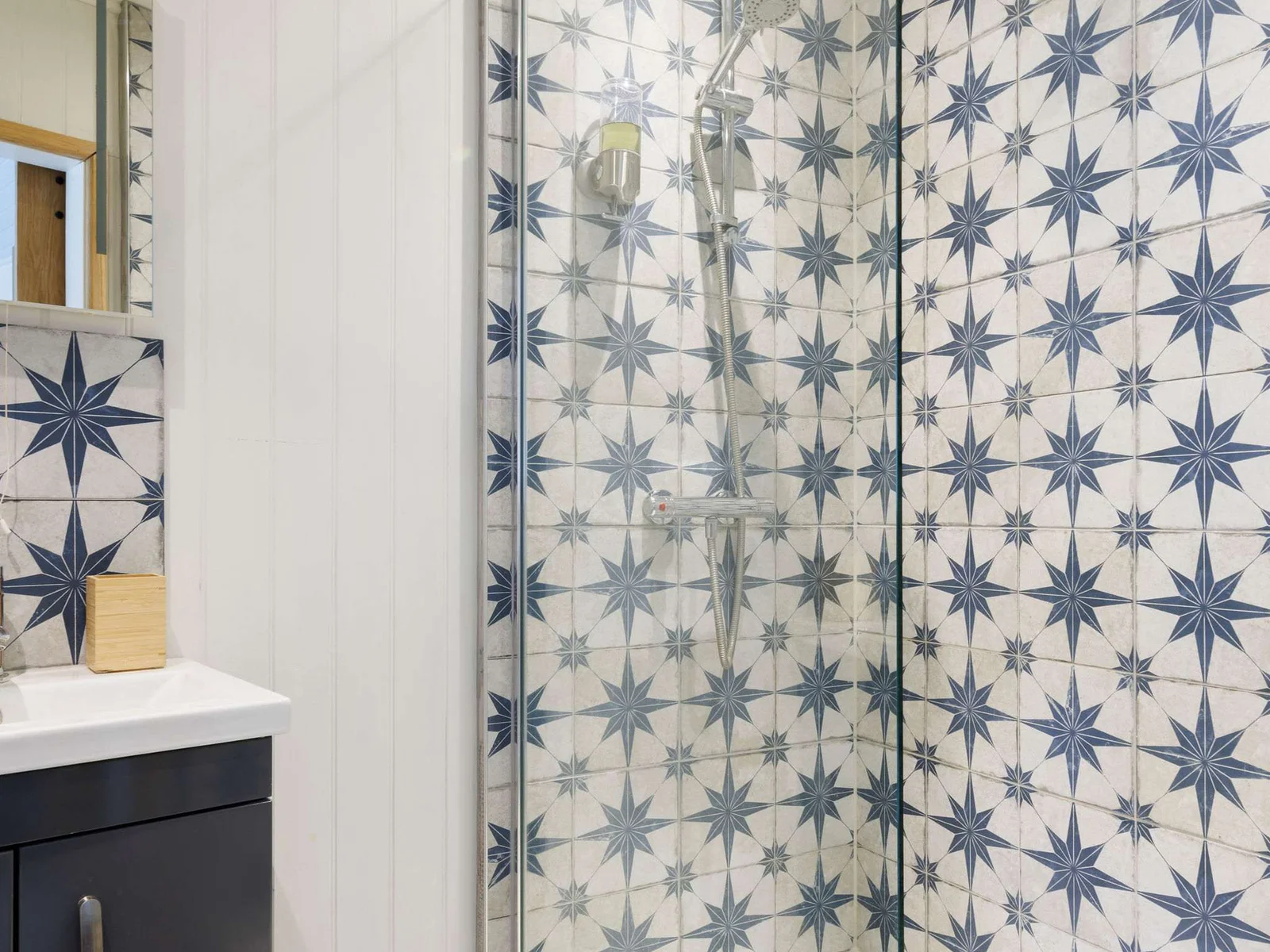 An overhead shower with gorgeous patterned tiles.