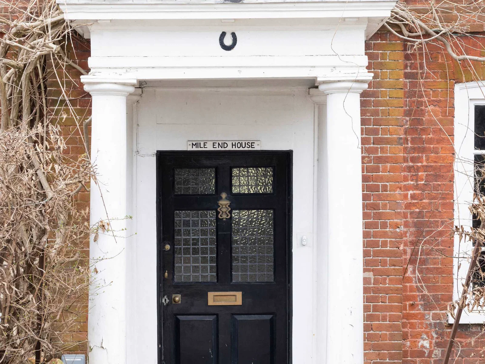 Grand entrance with classic red brick, white columns, and character by the bundle