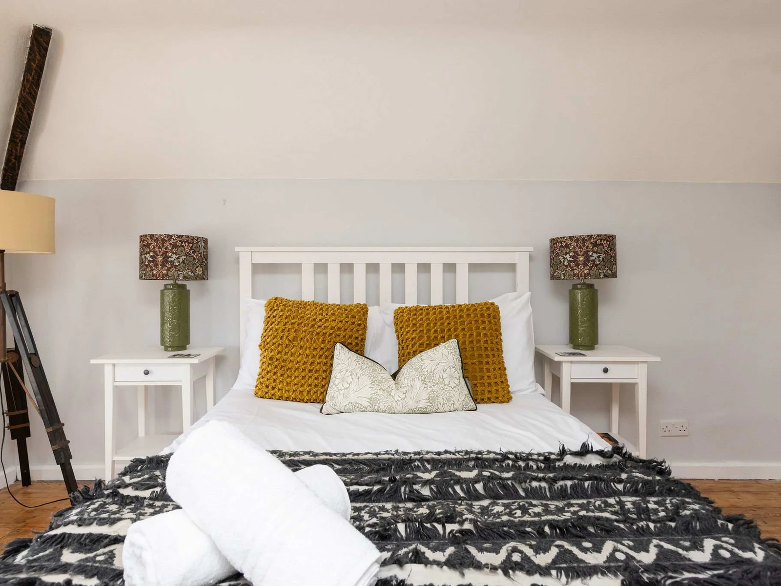 The master bedroom has a double bed with bedside tables and lamps.