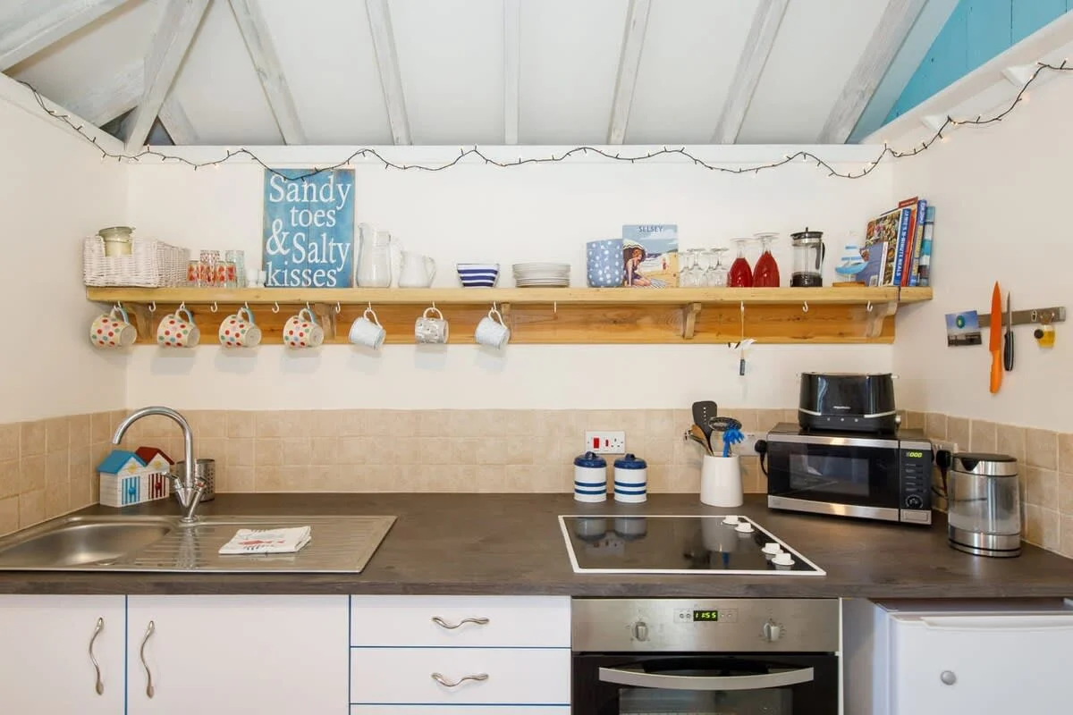 The kitchen has a toaster, kettle, microwave, oven and fridge.