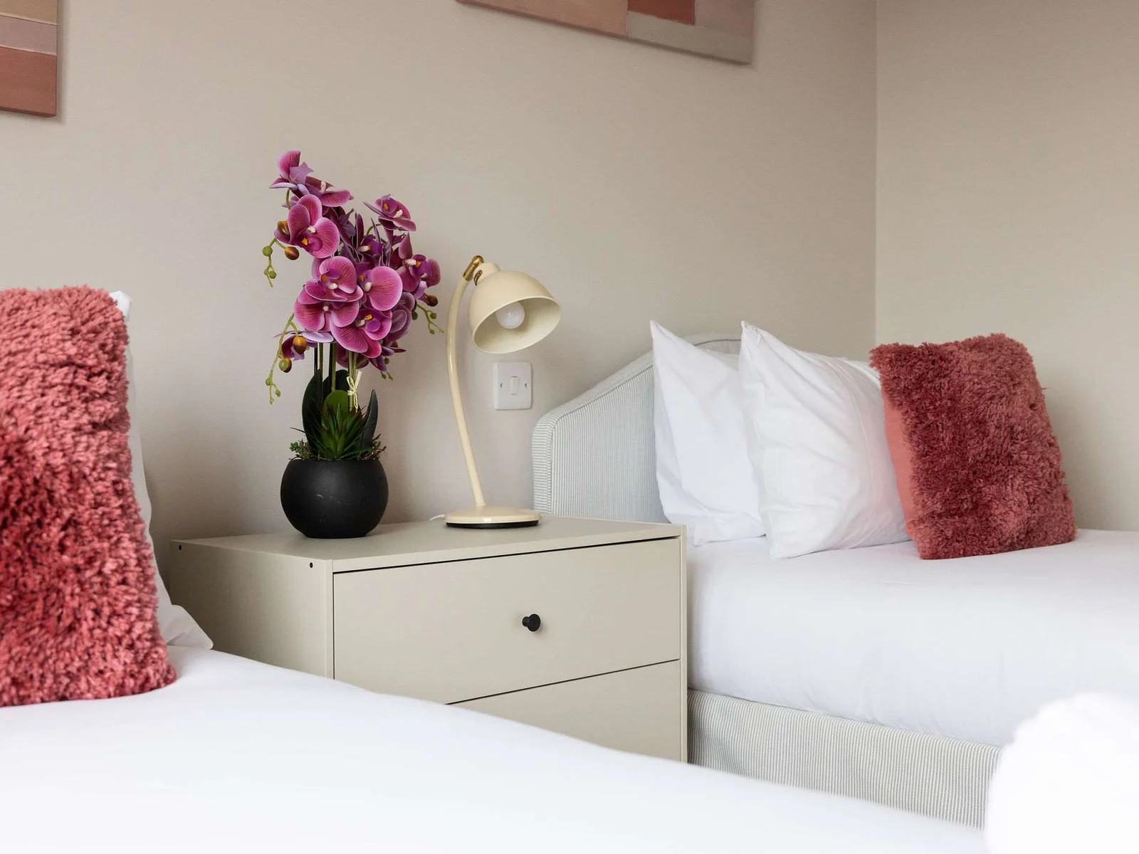 Decorative touches give the twin room a warm, polished feel, with handy bedside storage keeping the space practical as well as inviting.