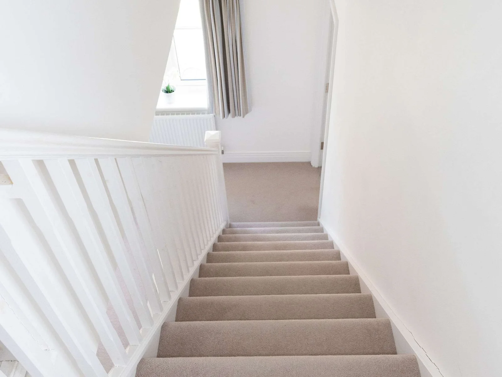 A bright, carpeted staircase leading to the upper floor.