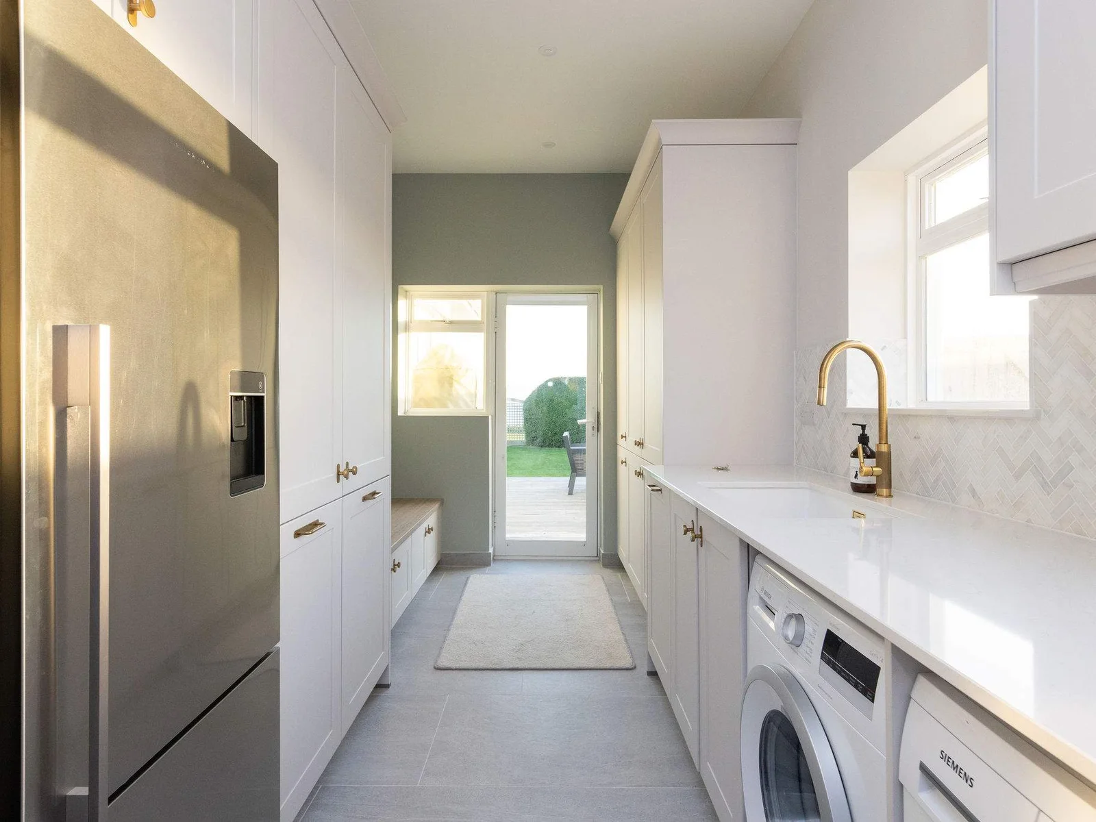 A large connecting utility room with further countertop space, storage and amenities.