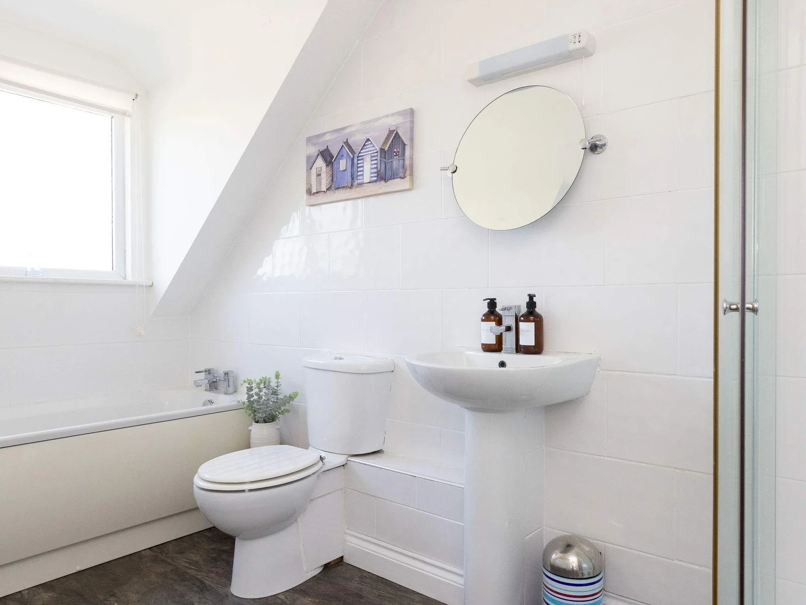 Freshen up in the bright family bathroom featuring both a relaxing bath and modern shower.