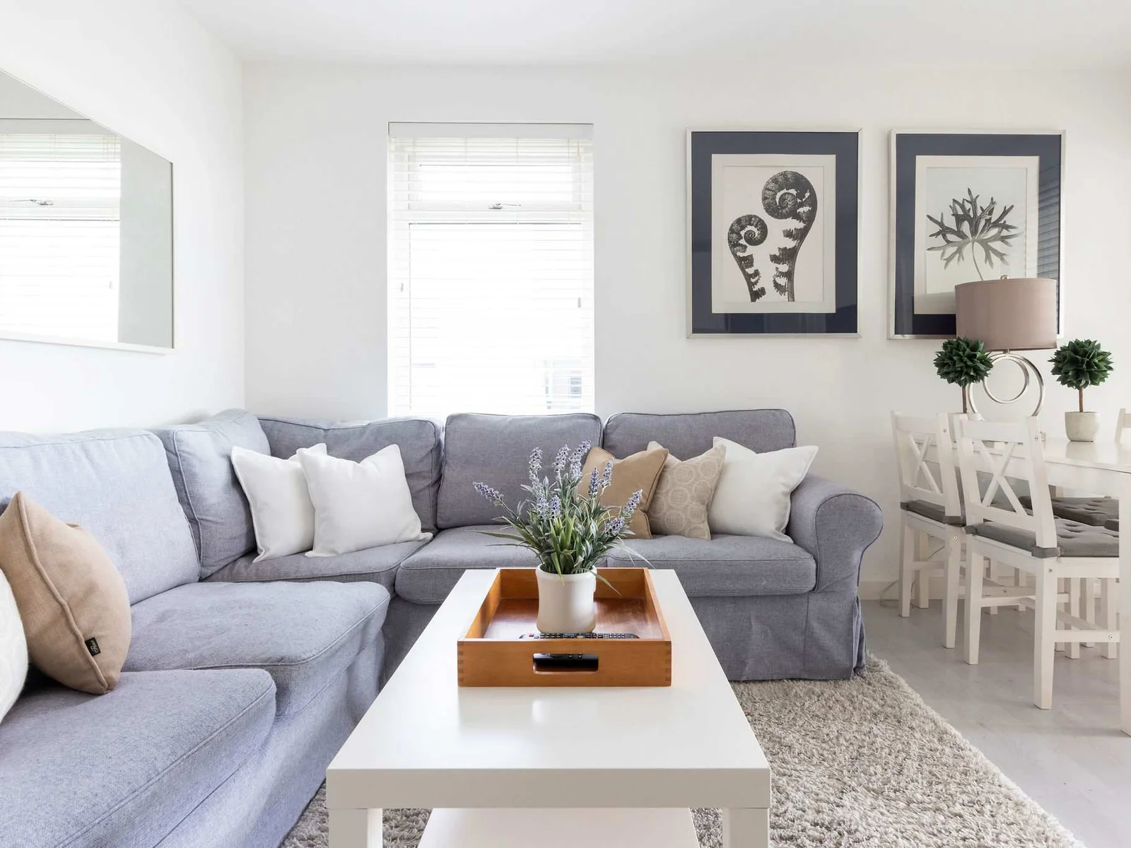 A spacious L-shaped sofa is accompanied with plush, comfortable cushions.