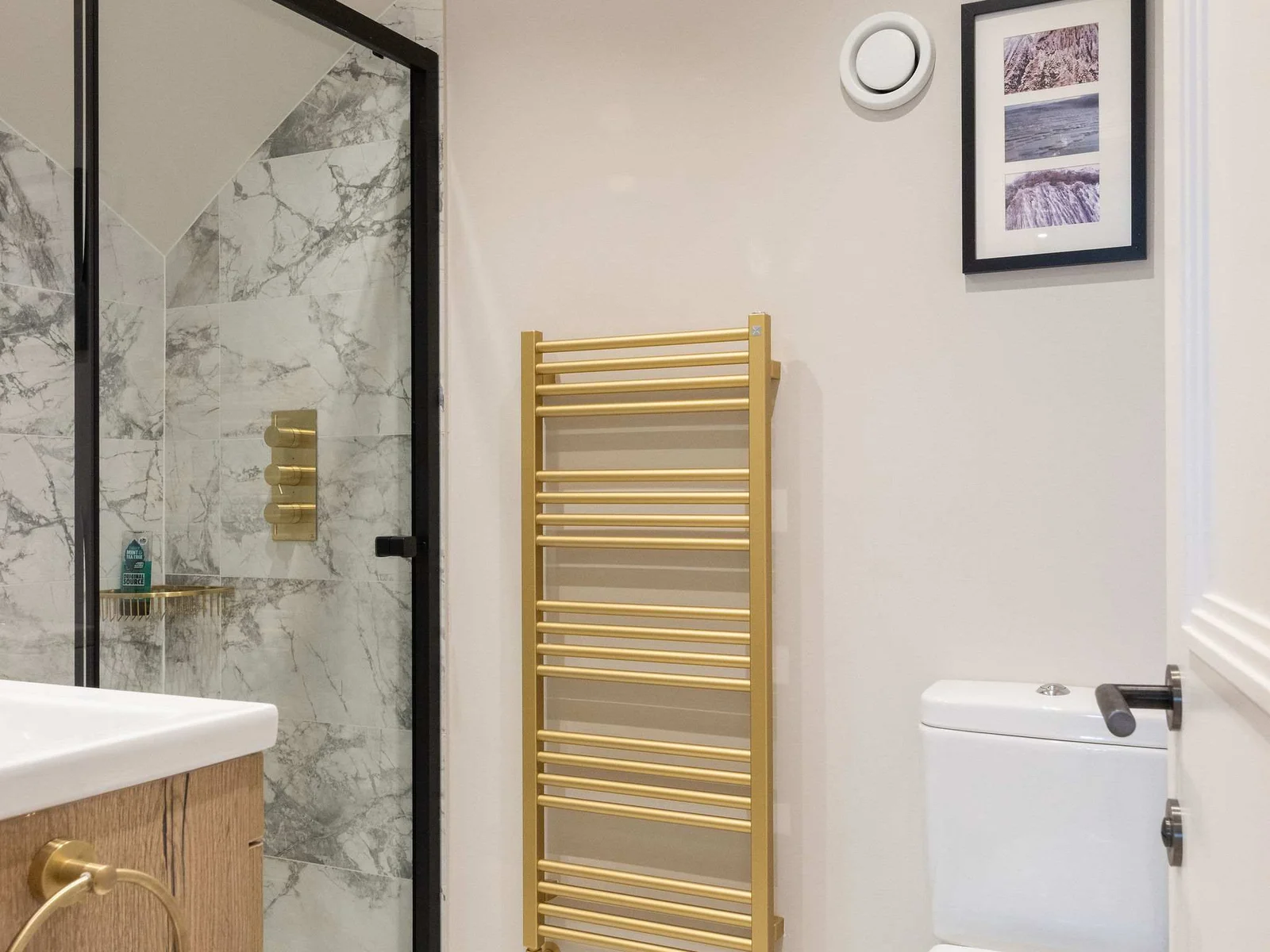 Elegant en suite with gold towel rail and marble tiles
