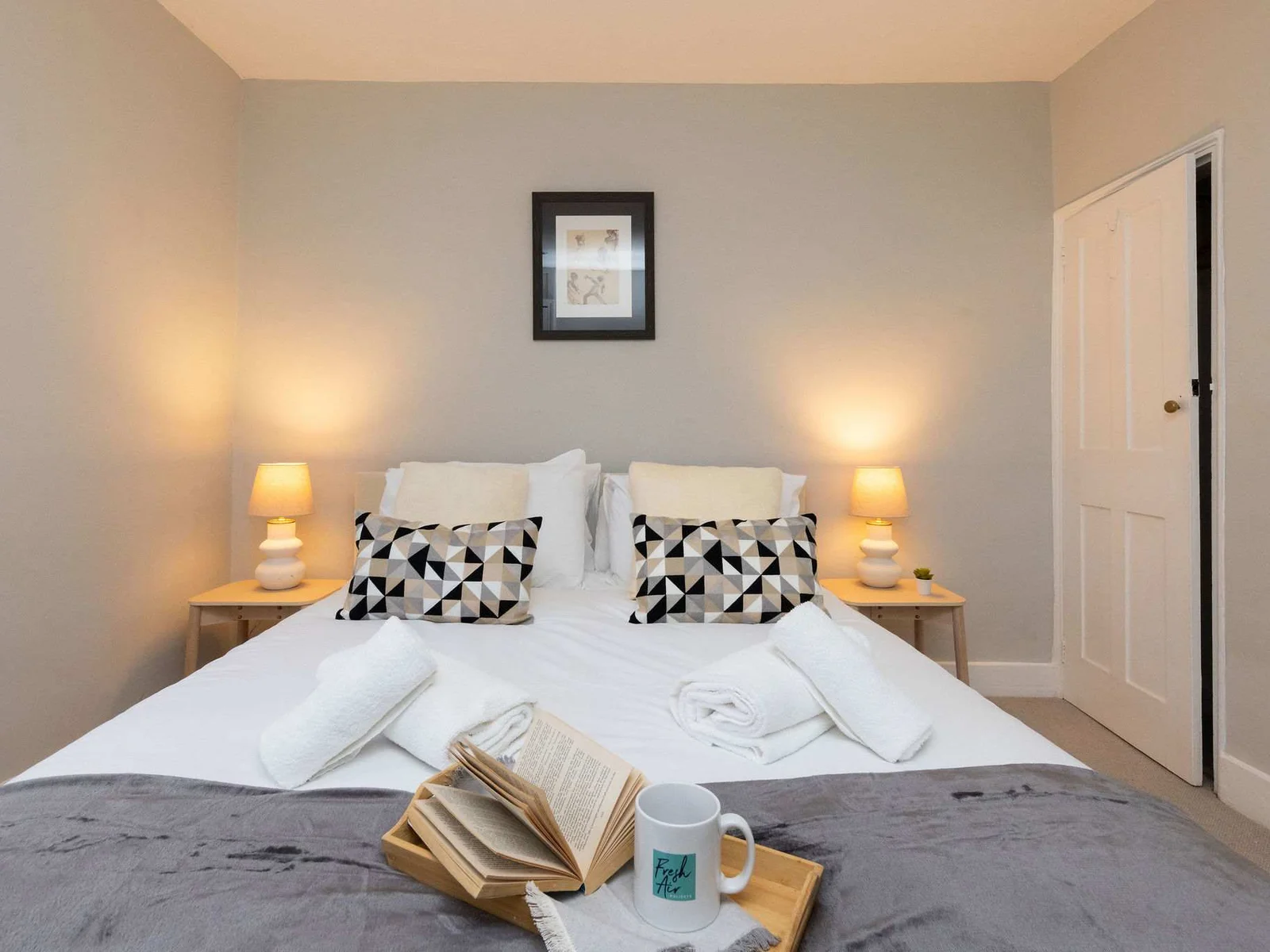 Bedside table with side lamps accompany this room perfectly.