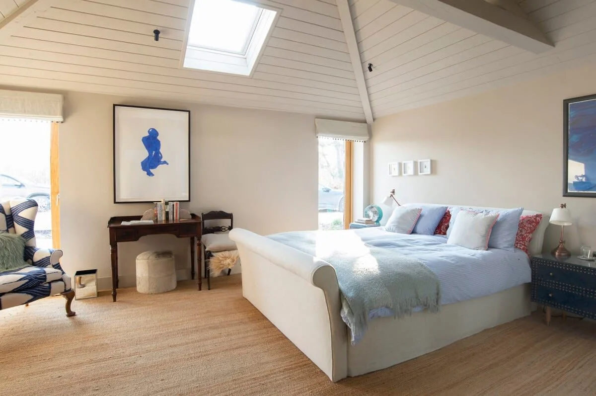 A wonderful bedroom with king bed, armchair and impressive artwork.