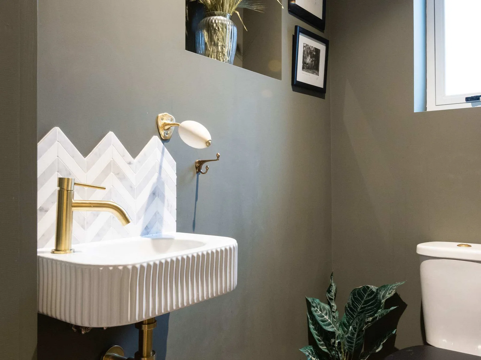 A stylish downstairs cloakroom with bold design and elegant brass details.