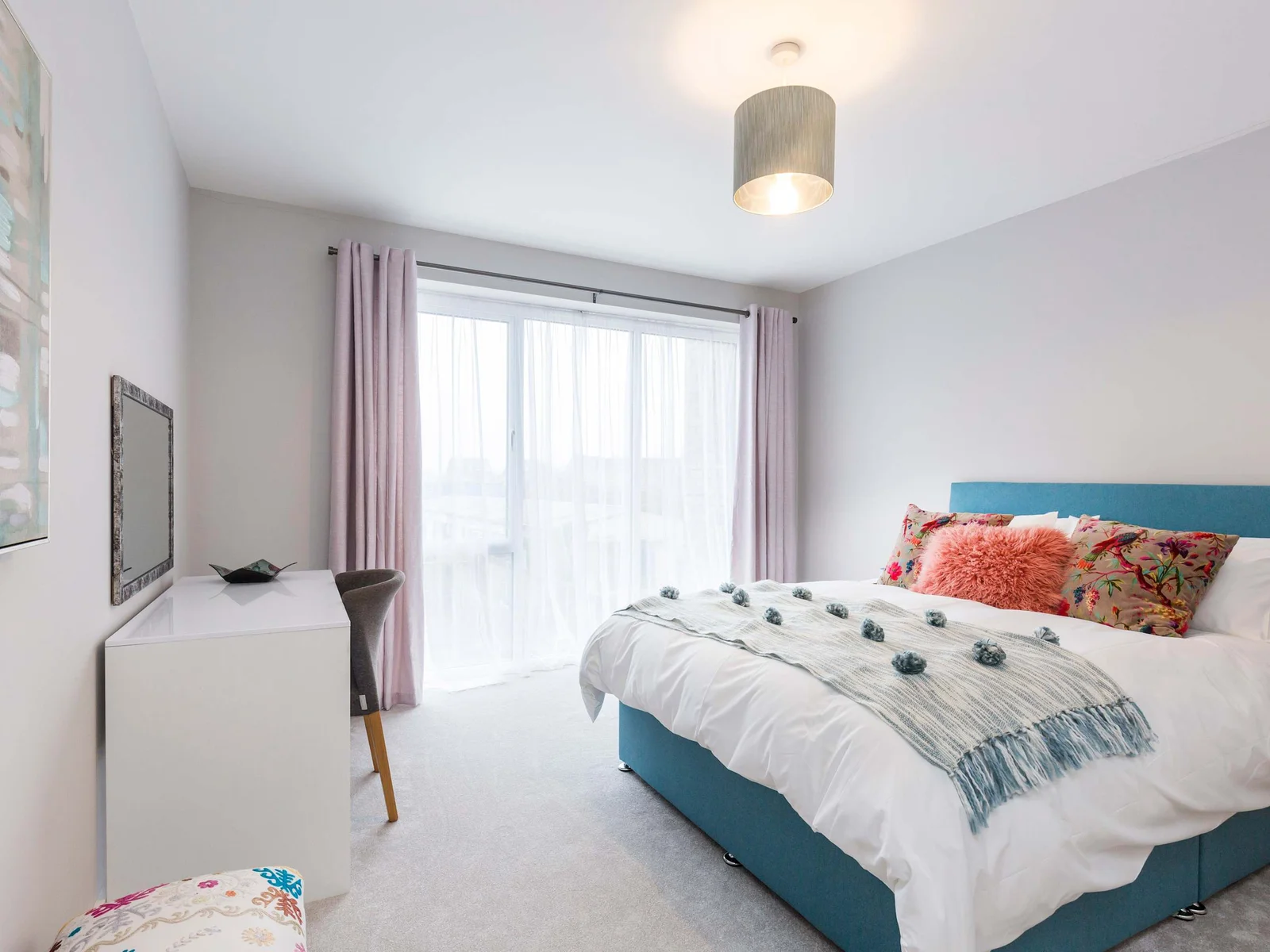Another of the double bedrooms featuring a king bed with a view of the window and dressing table.