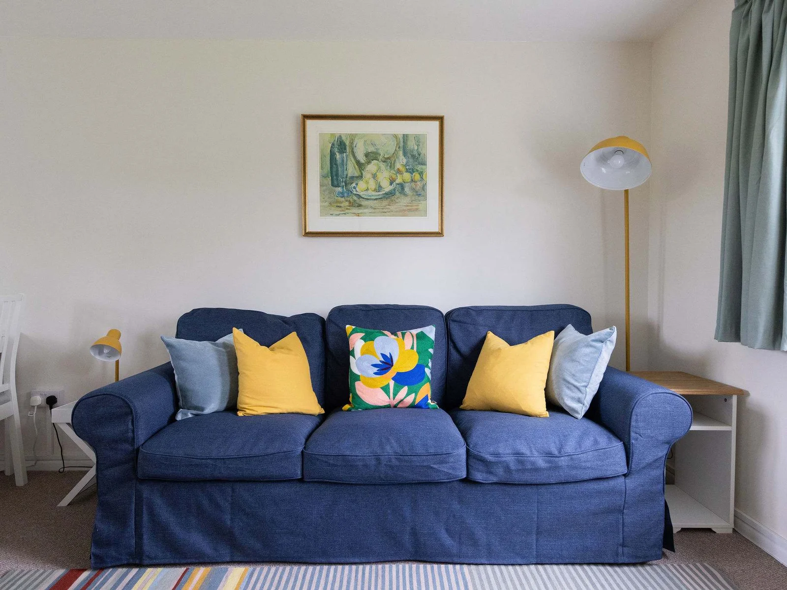Perfect for lounging with this cosy blue couch adorned with cheerful yellow pillows!