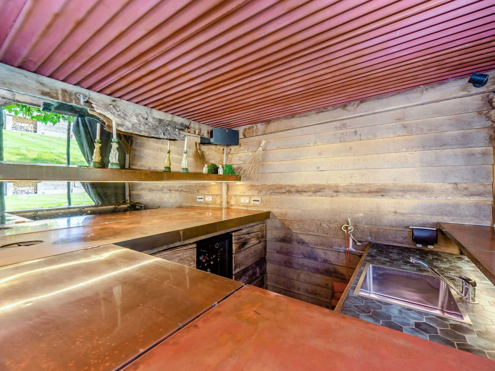 The rustic poolside bar with sink and fridge, perfect for drinks between swims and summer evenings