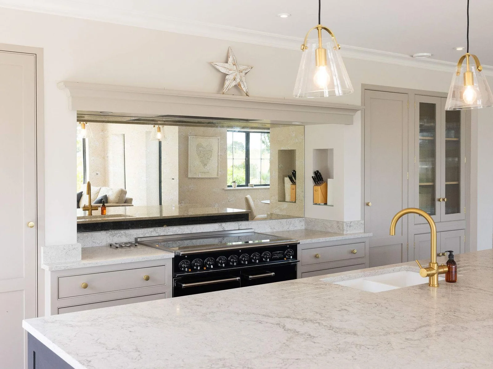 Sleek range and mirrored splashback in designer kitchen