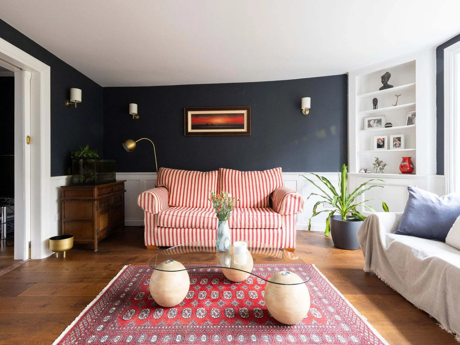 A cosy sitting area with a striped sofa, warm lighting, and elegant decor