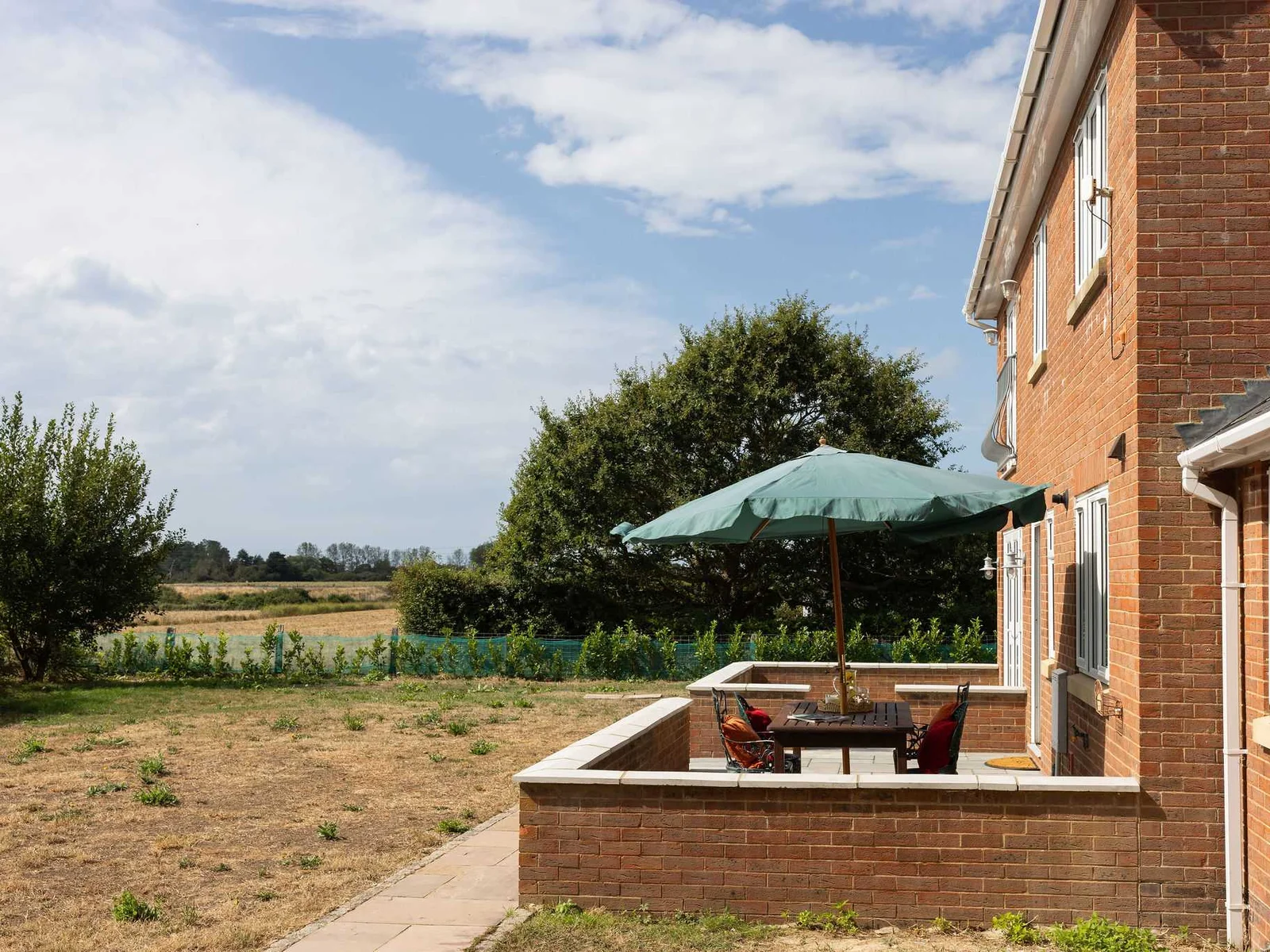 A sunny patio with outdoor seating overlooking the garden and open countryside — a lovely spot for al fresco lunches, evening drinks or simply enjoying the rural setting.