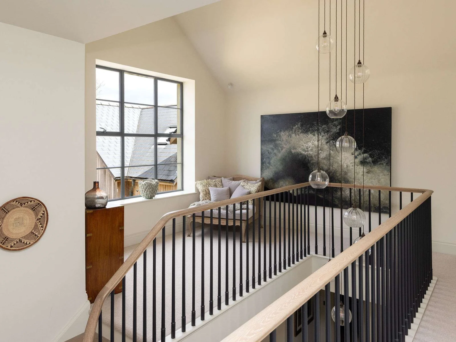 A curated landing with statement lighting and artful touches reflecting the home's exceptional design.
