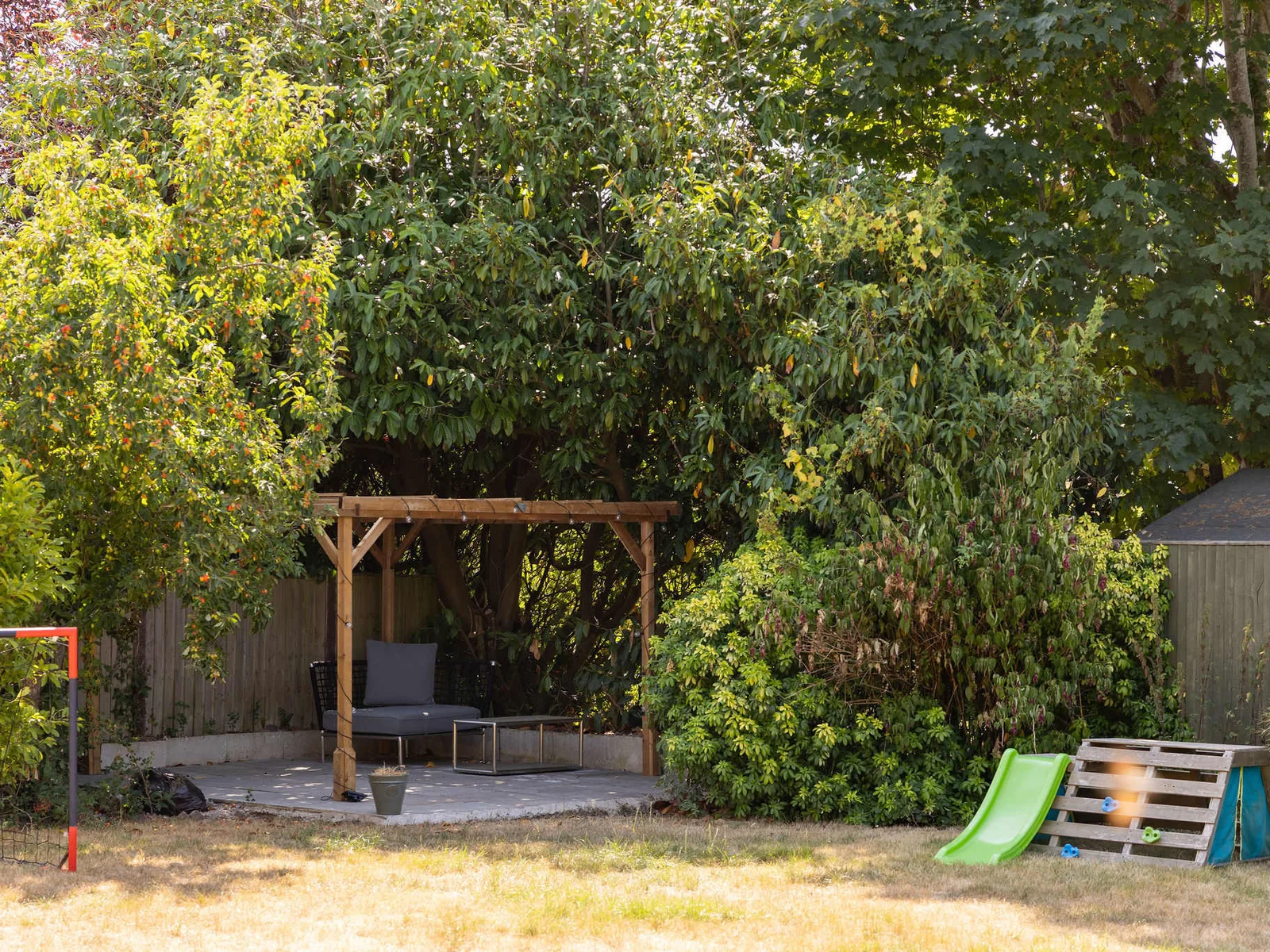 Tucked away at the bottom of the garden, this charming patio offers a peaceful spot to sit and unwind, with comfortable seating and soft lighting creating a lovely atmosphere as the day draws in.