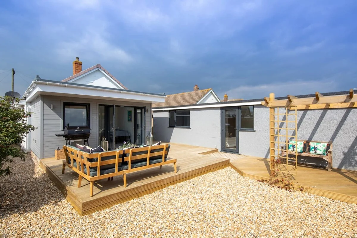 Wooden deck offers a comfortable lounge and a modern BBQ grill
