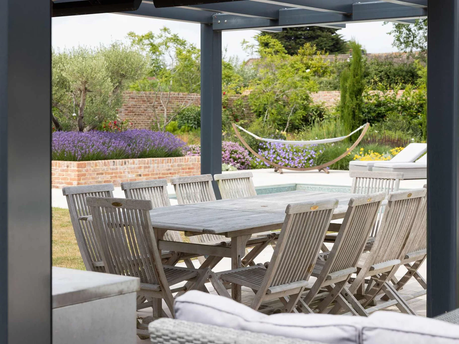 Dine alfresco under the pergola, with views of lavender beds, hammocks, and rolling countryside