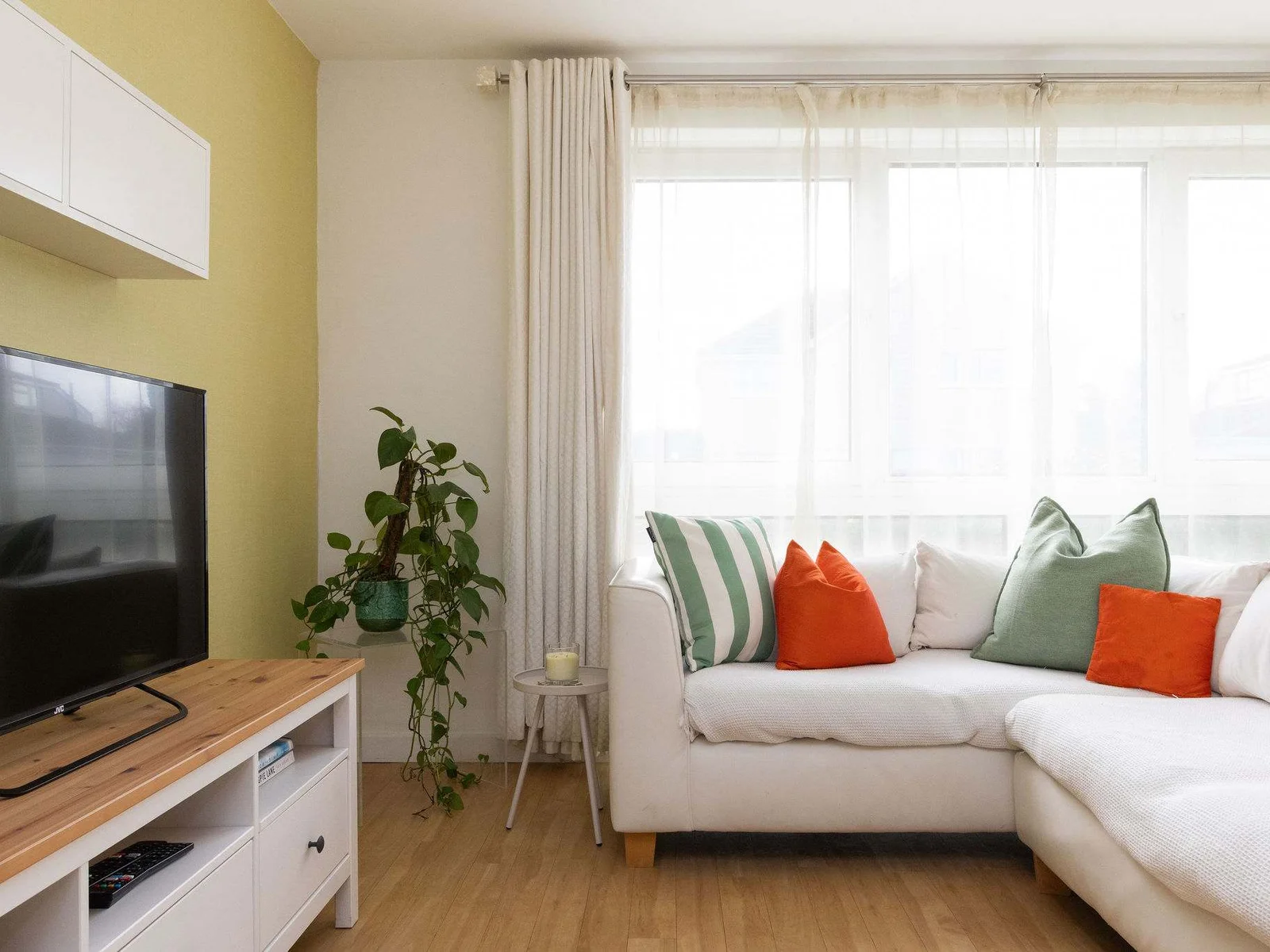 Bright open-plan living area with comfy corner sofa and Smart TV, perfect for relaxing after the beach.