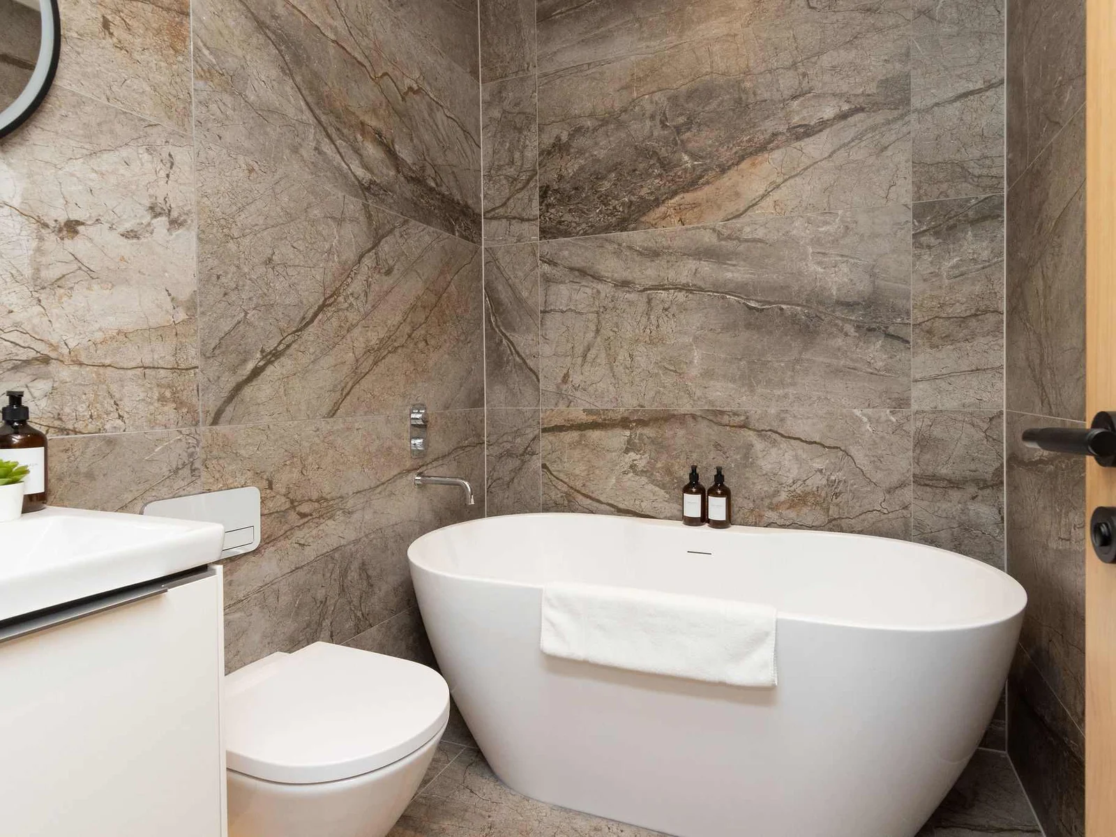 Modern bathroom with freestanding bath and stone-effect walls