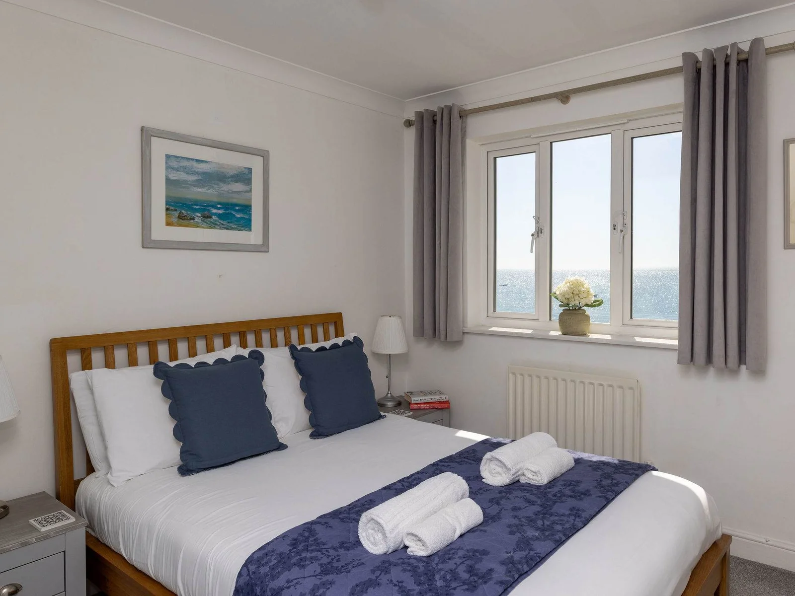 Bright double bedroom with calming décor and beautiful sea views for a relaxing coastal escape.
