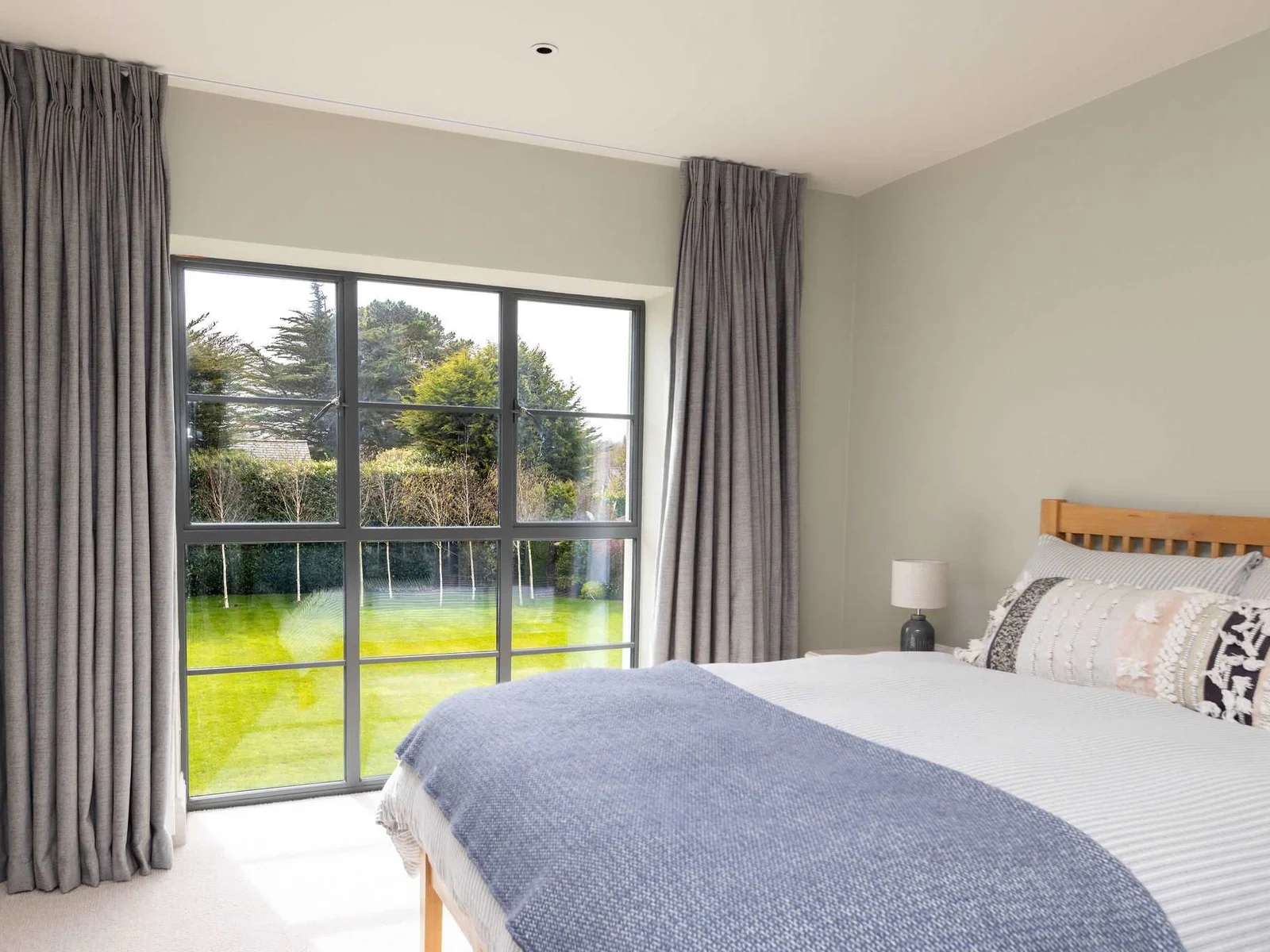 Bright double bedroom overlooking the lush green garden, perfect for a restful night's sleep.