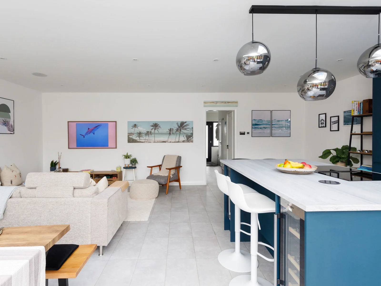 The kitchen island serves as a breakfast bar for 4 with overhead pendant lighting.