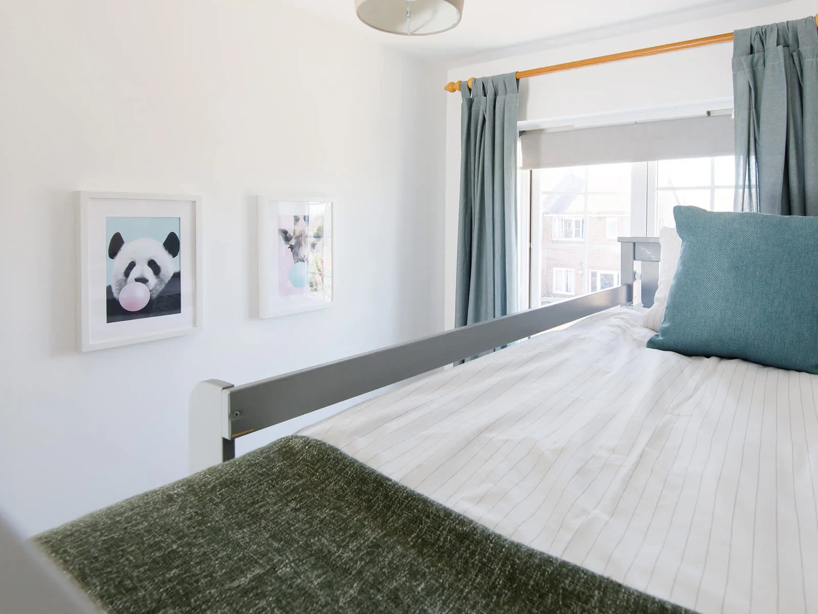 The children's bunk room has lovely pillows, throws and fun wall prints.