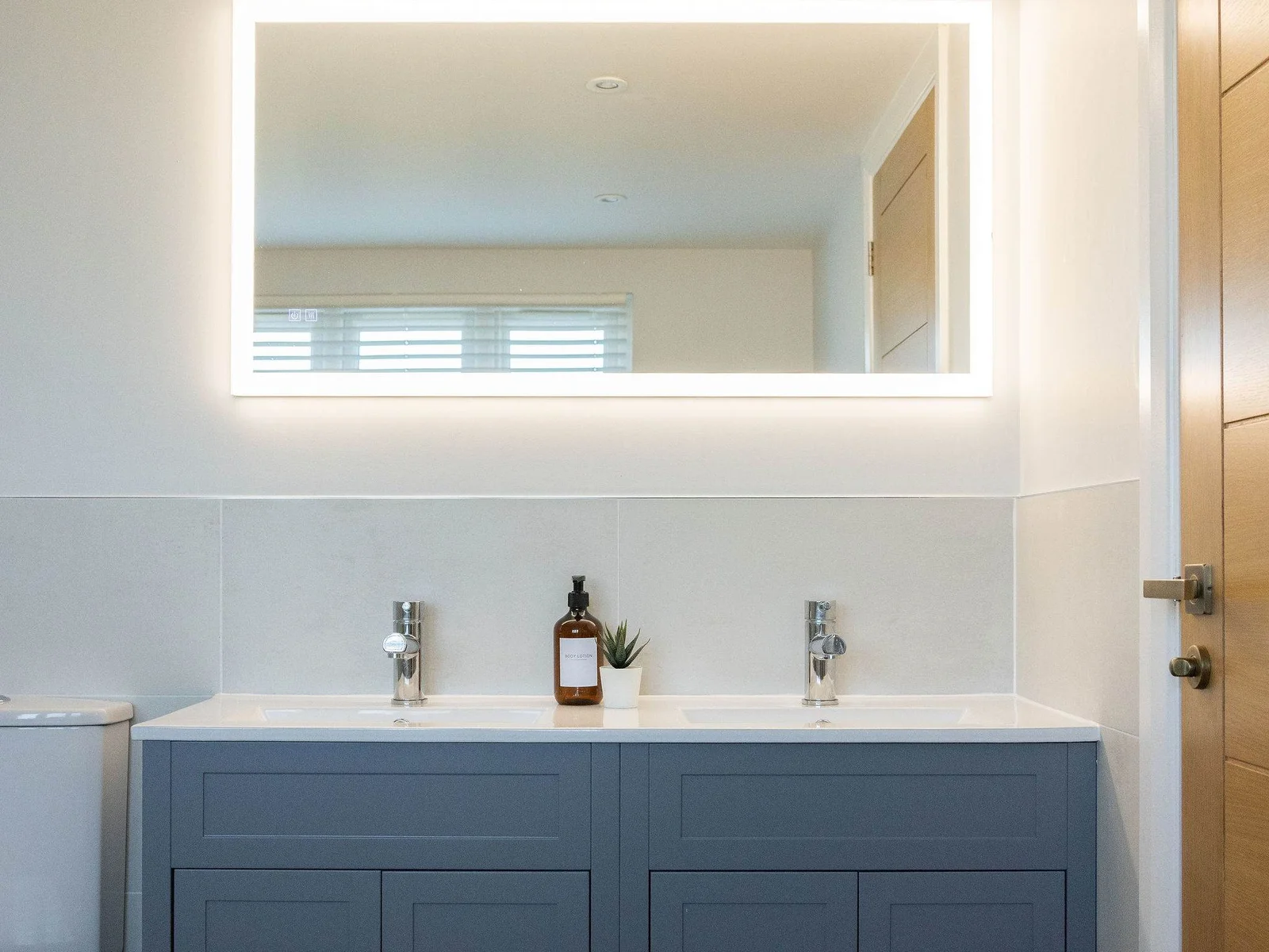 His and hers sinks with a large overhead led mirror