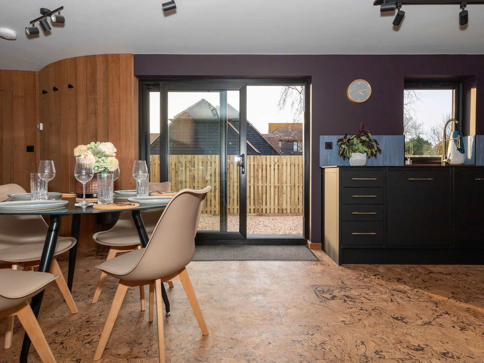 The sliding doors open out to the gravel driveway.