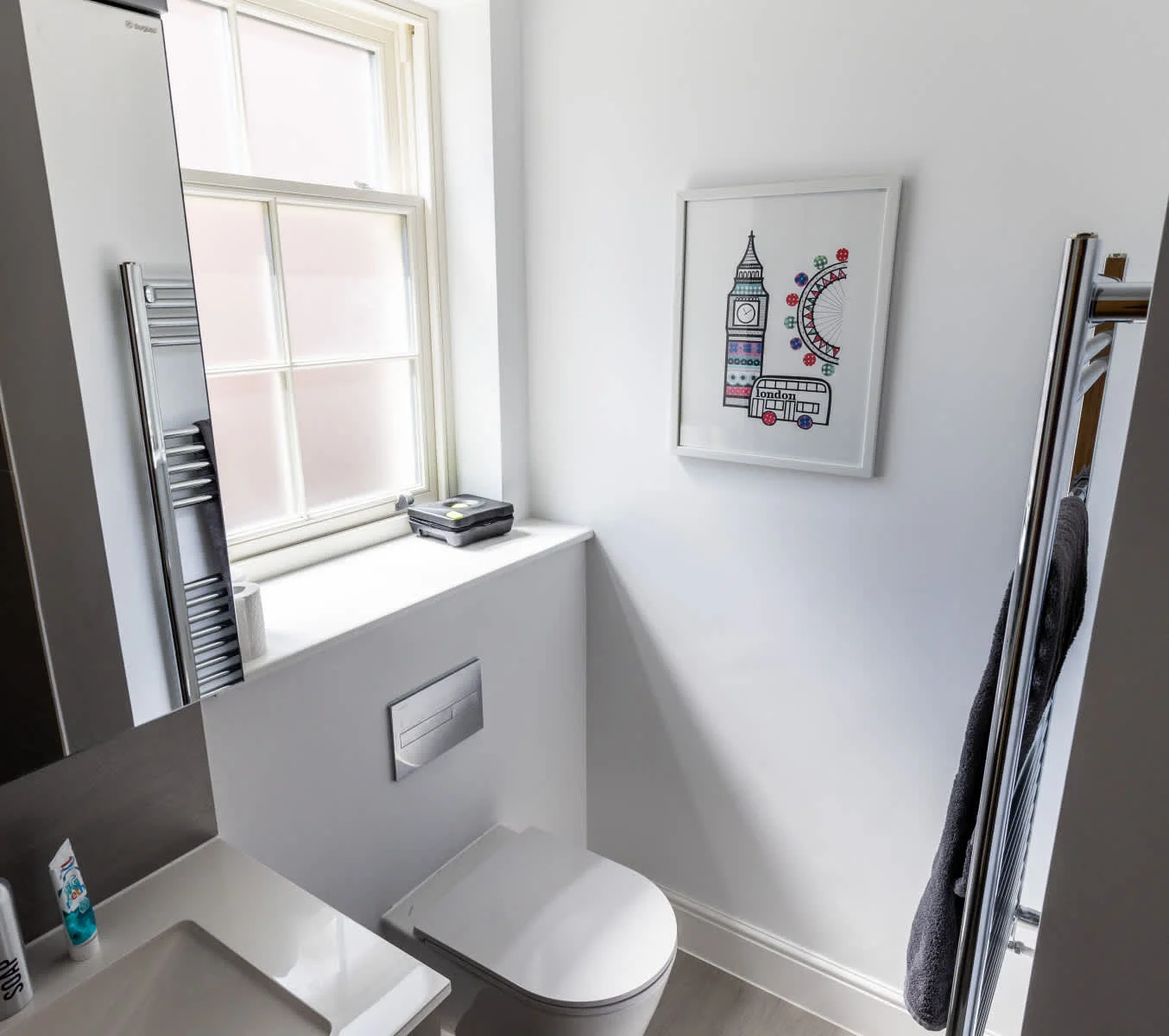 Modern ensuite bathroom with sleek fittings, WC, sink and heated towel rail.