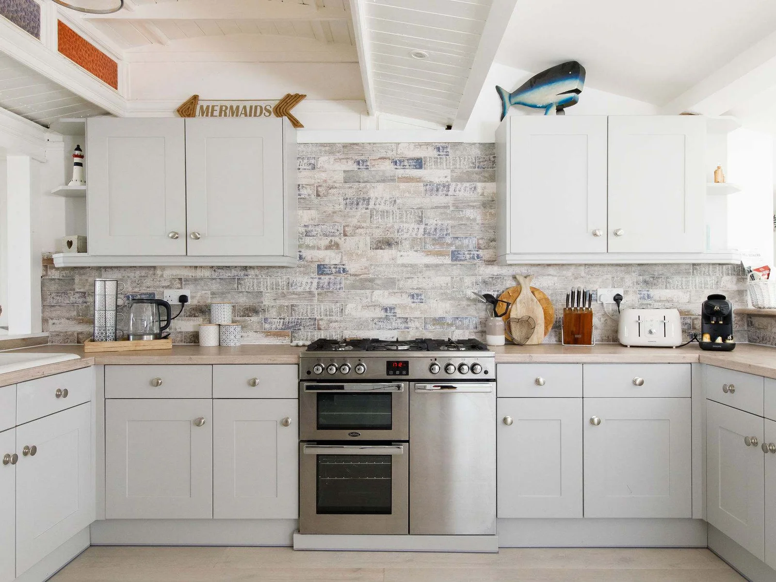 There is a Nespresso coffee machine, kettle, toaster, double oven, dishwasher and hob.