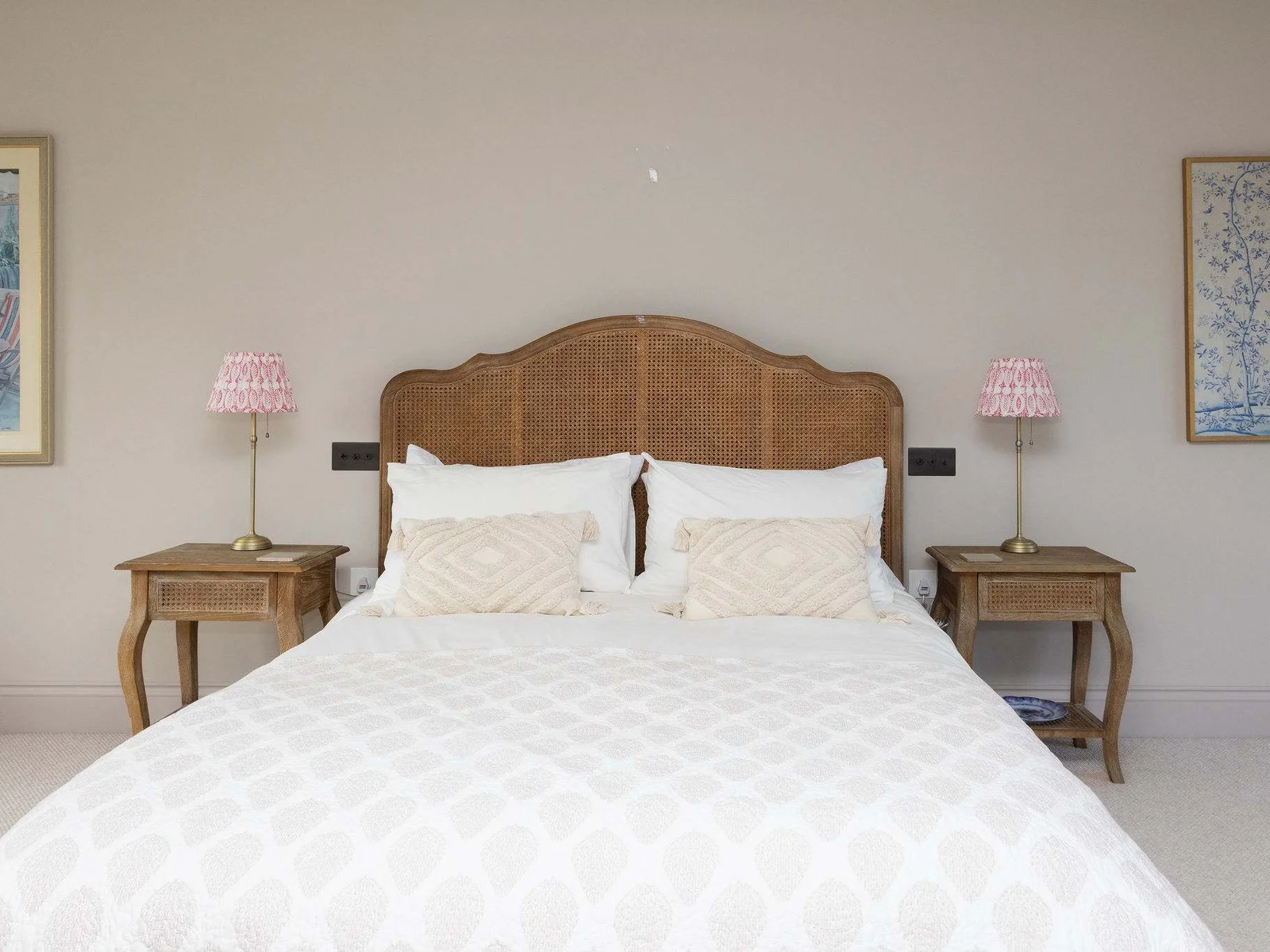 Thoughtfully styled bedroom with a rattan headboard, quality linens, and warm coastal touches.