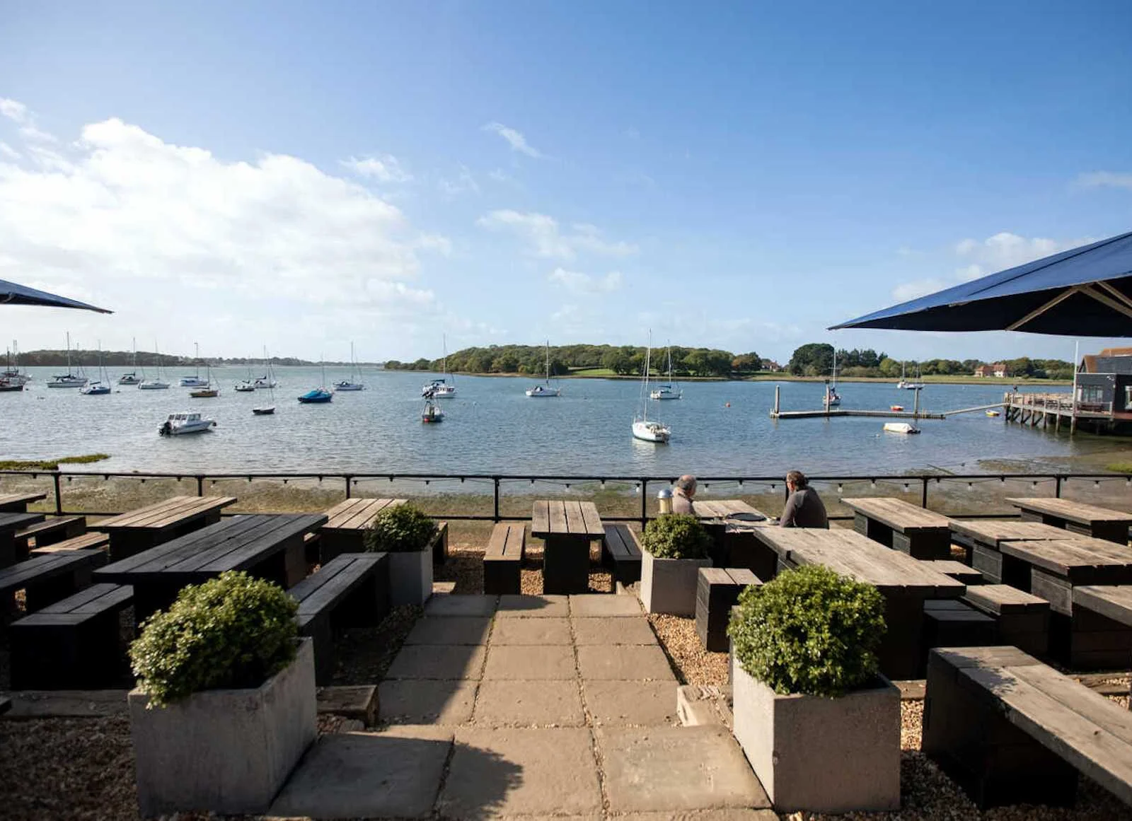 Enjoy amazing waterside views from the terrace at The Crown & Anchor, Chichester. Just a 12-minute drive away.