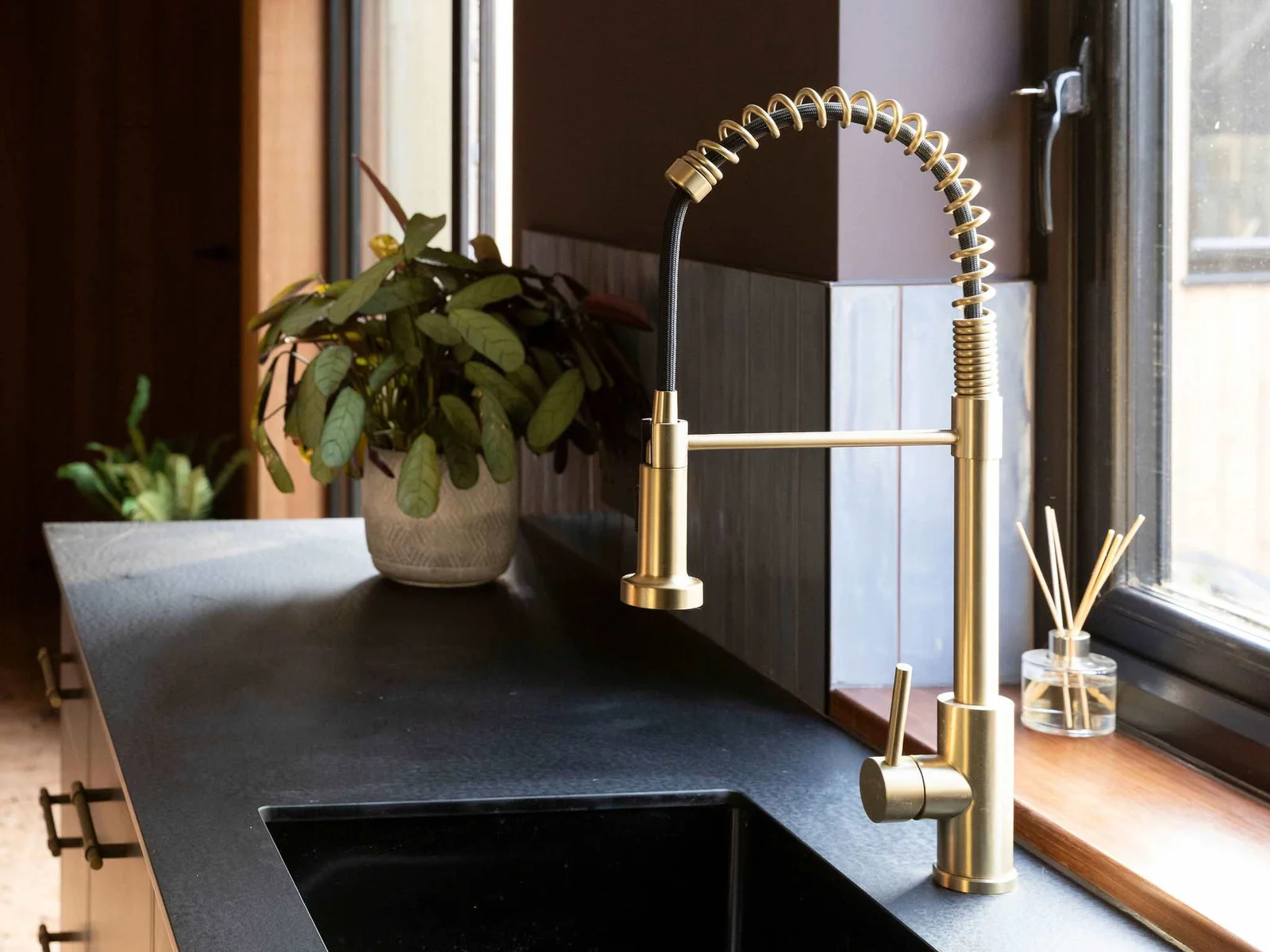 The kitchen sink is fitted with a stunning gold tap.
